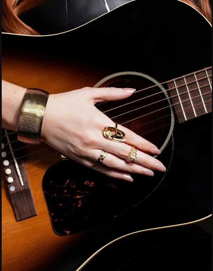 Luxury Jewelry — Fine rings styled with a guitar for a dark music-inspired campaign still life.