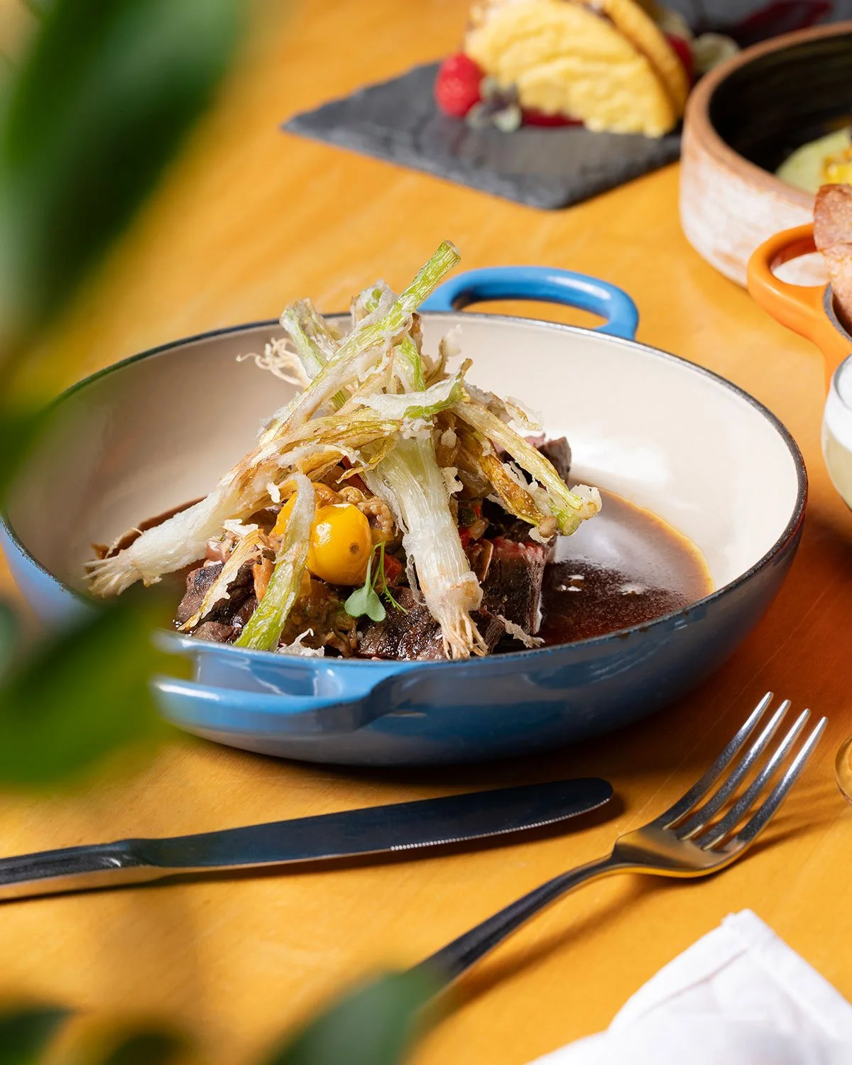 Hospitality — Brasstown bavette steak plated with crisp vegetables in a blue serving dish for a seasonal restaurant menu.