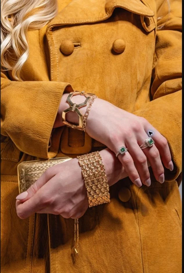 Luxury Jewelry — Assorted bracelets and rings styled on a mustard trench coat in a cinematic fashion editorial.