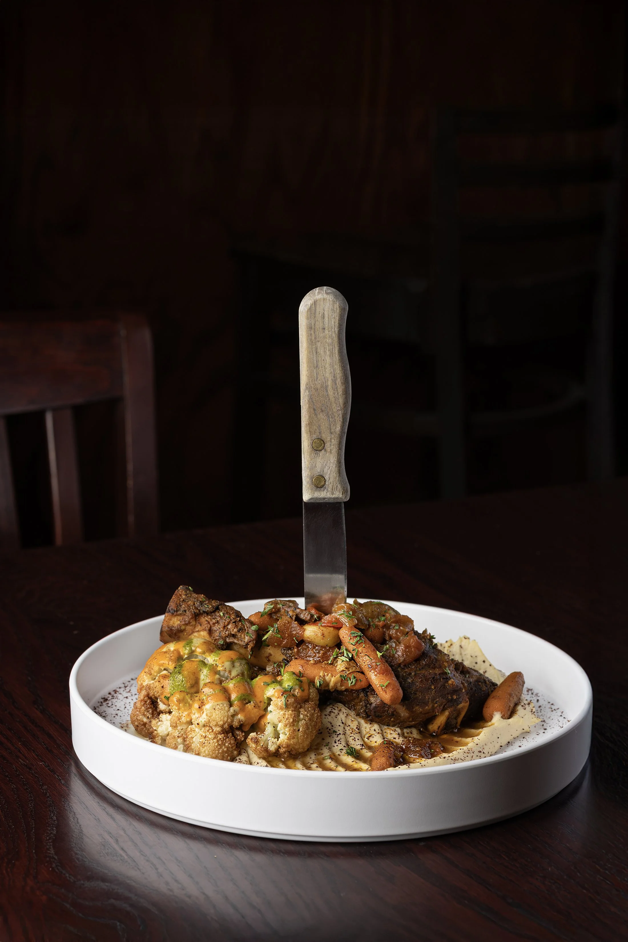 Braised lamb shank plated for Jerusalem Garden, photographed by Fraiche Photography in Asheville, North Carolina.