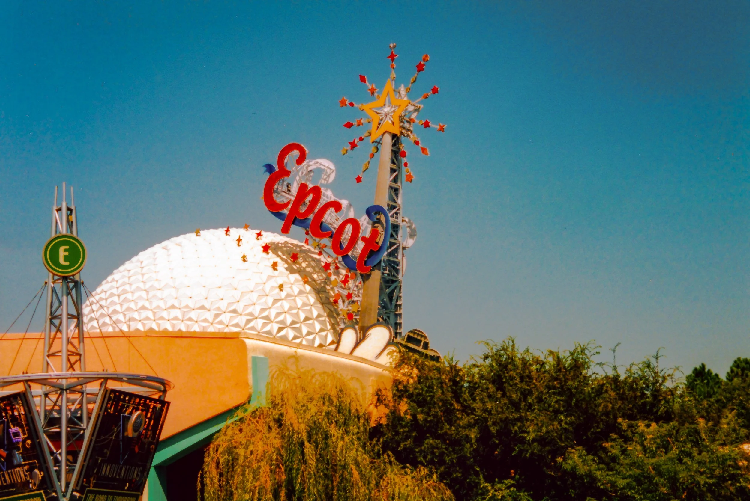 Epcot theme park entrance with a large geodesic sphere and decorative star-shaped and arrow elements on top.