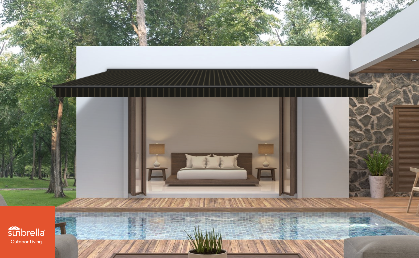 A modern outdoor living space featuring a pool, wooden deck, and a bedroom with sliding glass doors. The bedroom has a bed with white bedding, two bedside tables with lamps, and is situated under a black, striped awning. The background includes lush green trees and a stone wall with a potted plant nearby.