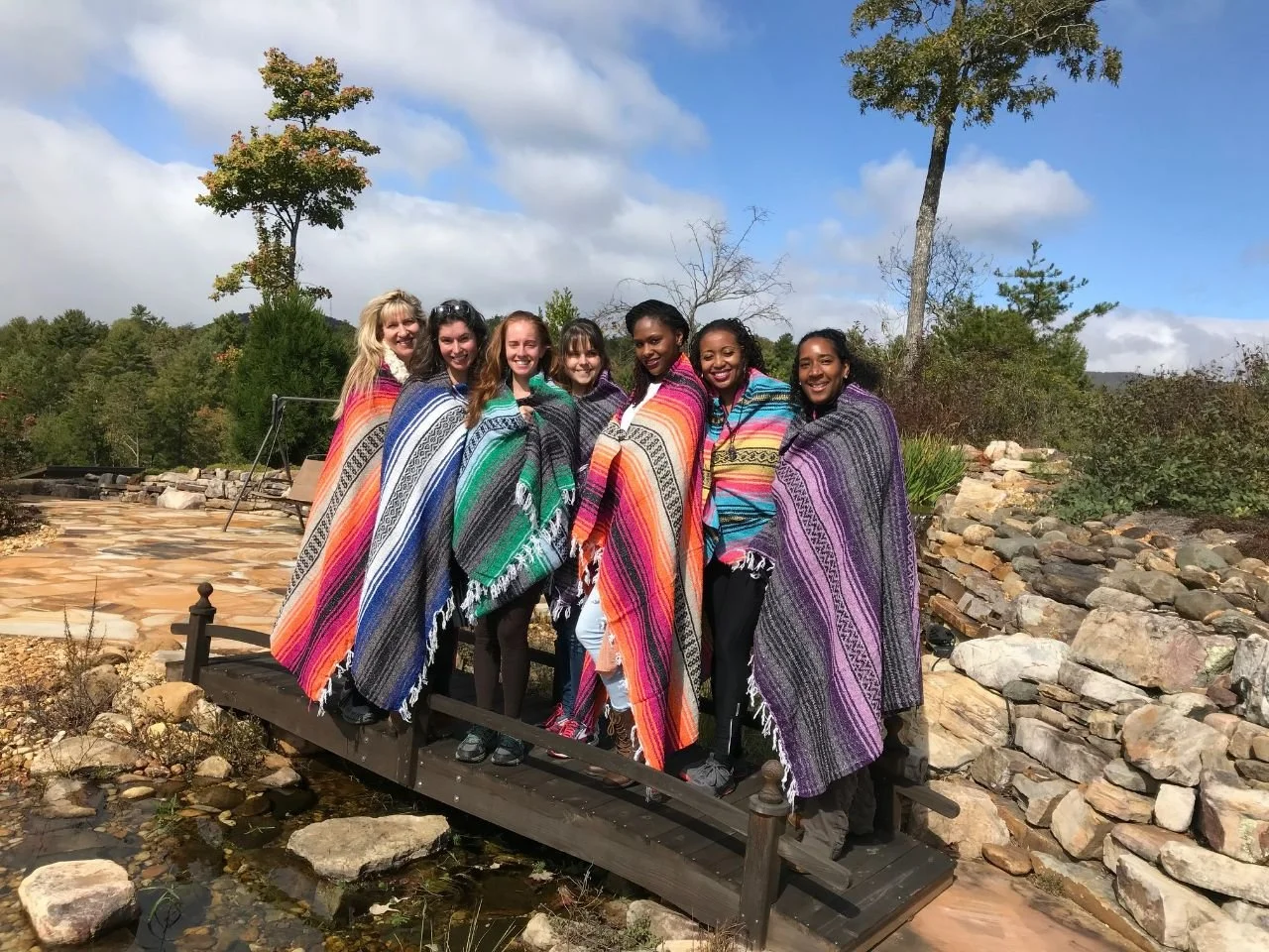 Prachel with women on a bridge during a shared travel experience.