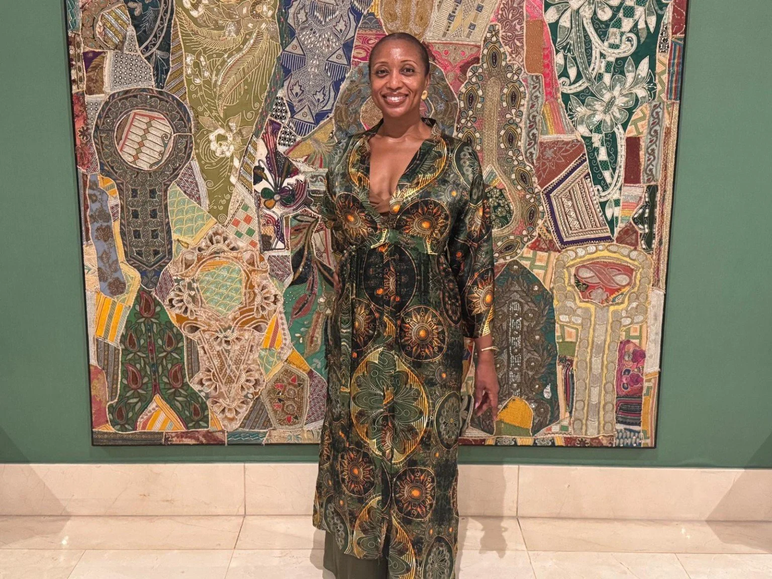 Prachel at an art exhibition in a patterned dress.