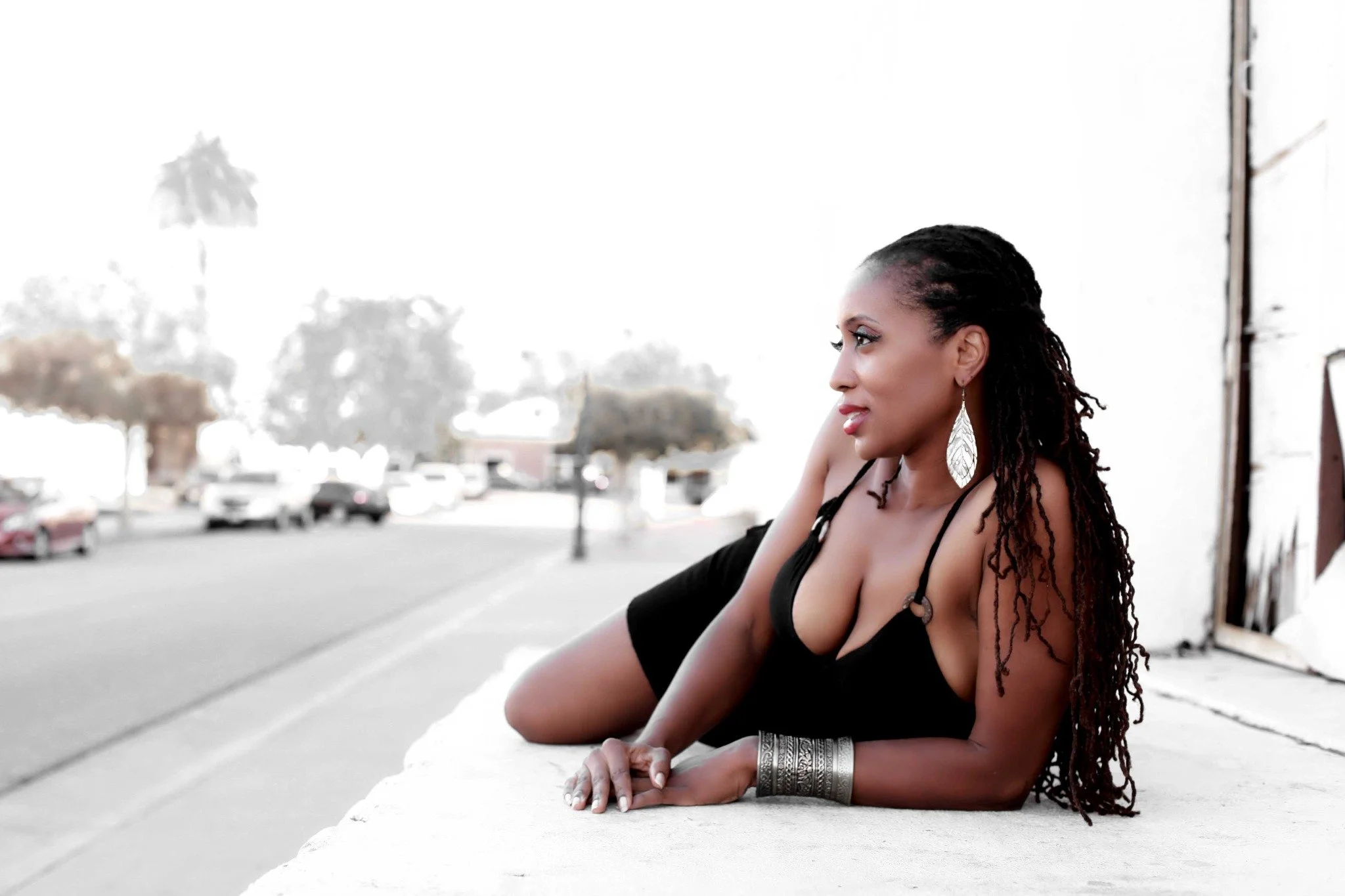 An archival modeling portrait of Prachel Carter reclining outdoors in a black dress.