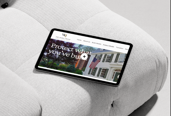 A tablet displaying a website about protecting what you've built, resting on a light gray upholstered sofa.