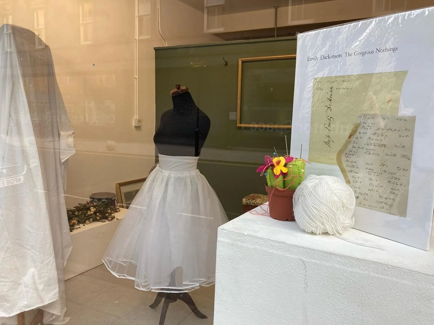 an image of the sign in the window of the exhibition showing the book of Emily Dickinson's poetry as written on envelopes
