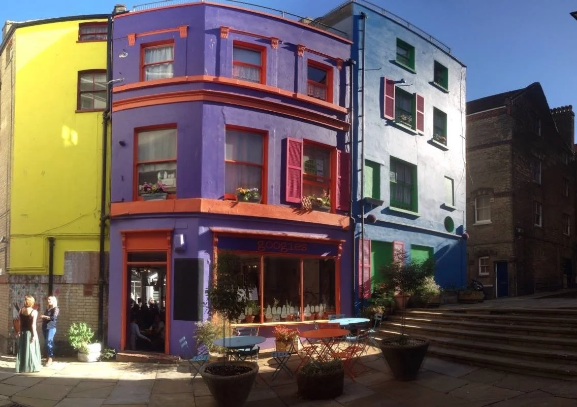 An image of a colourful town square in the sun in bright yellow, purple, pink, orange and blue. I wrote the funding bid and co-edited it with a local business and created an in situ sculpture to commemorate the life and work of Noel Redding
