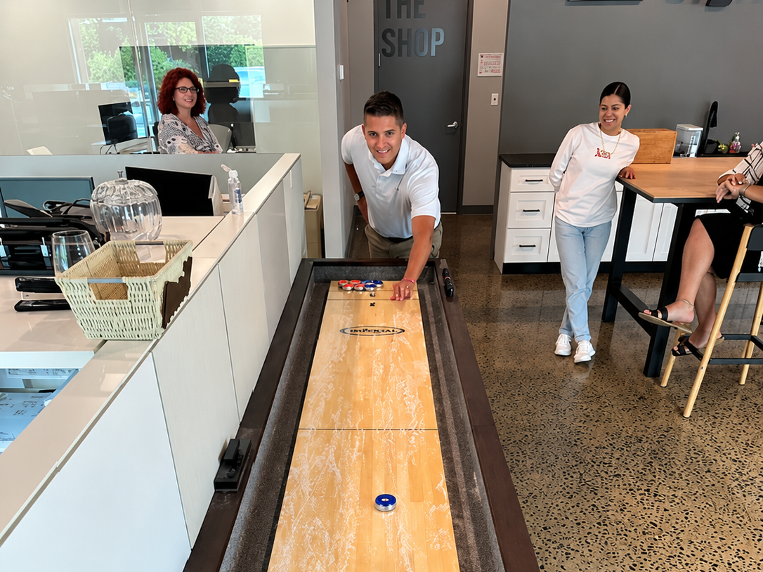 Tim trying to score a get out of work early in shuffleboard points for the Team
