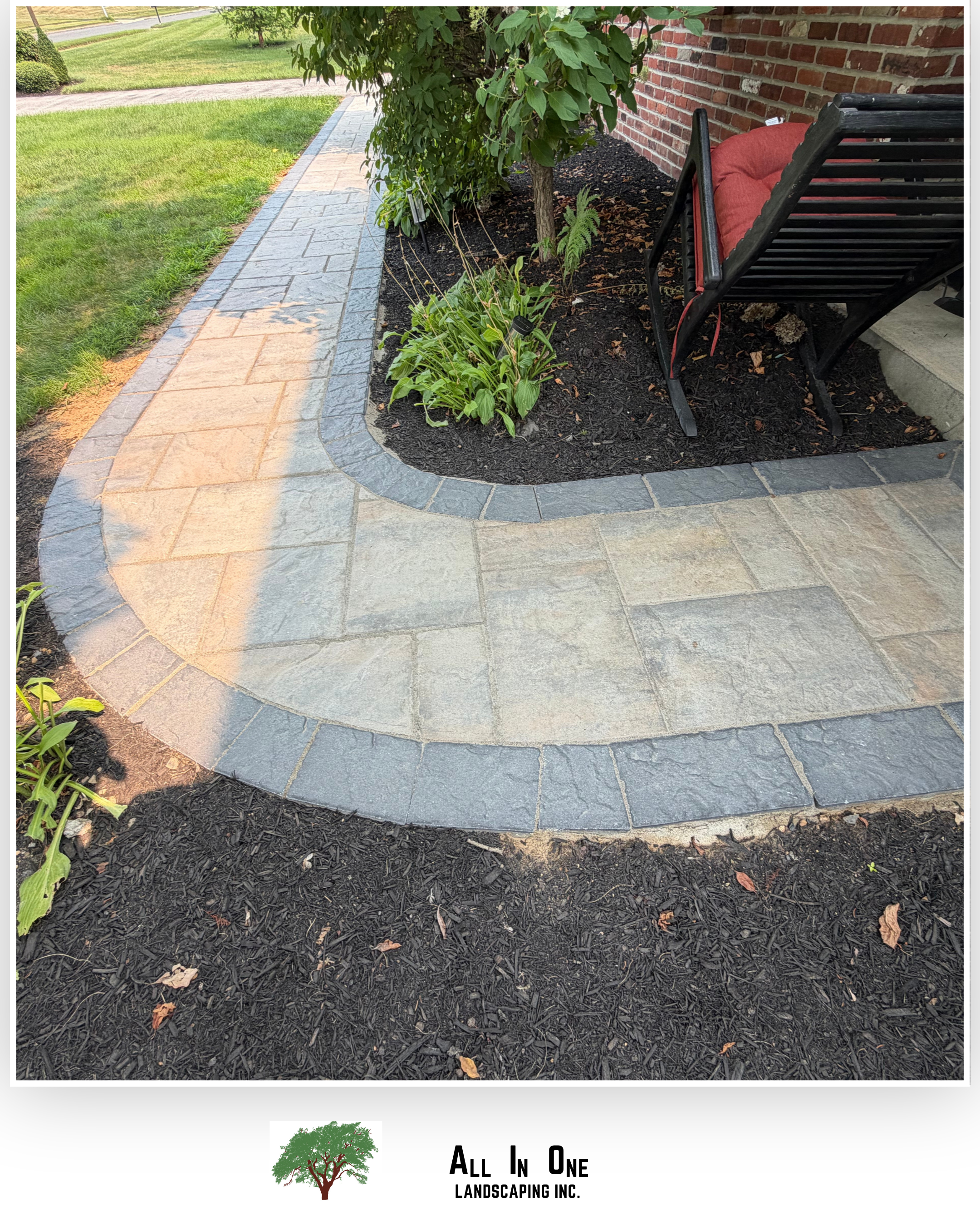Custom paver walkway with a curved layout, contrasting stone borders, and adjacent planting beds, creating an attractive transition between outdoor areas.