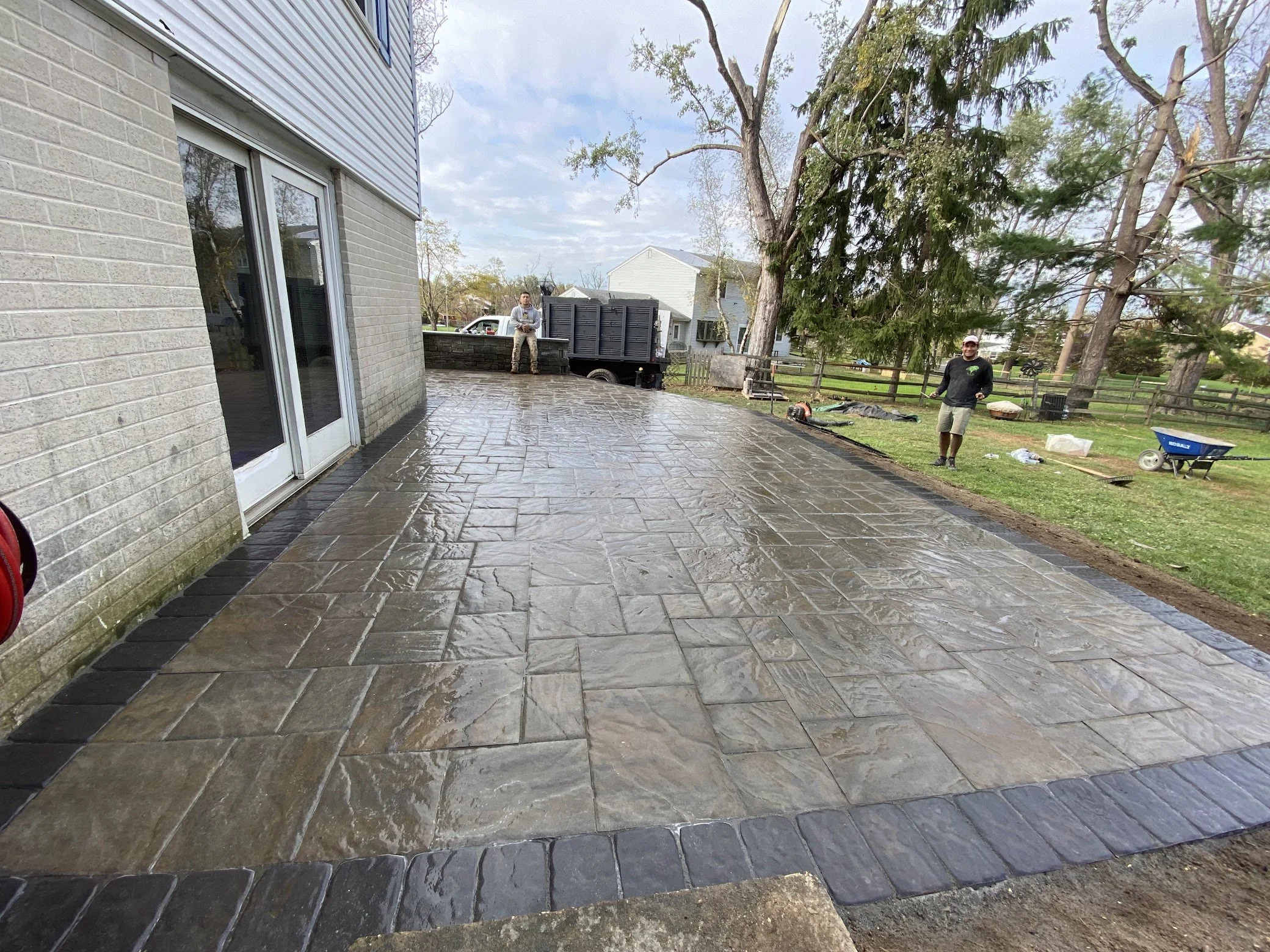 Residential outdoor surface featuring a decorative stone-style pattern and defined edges, providing a practical patio area with a textured finish.