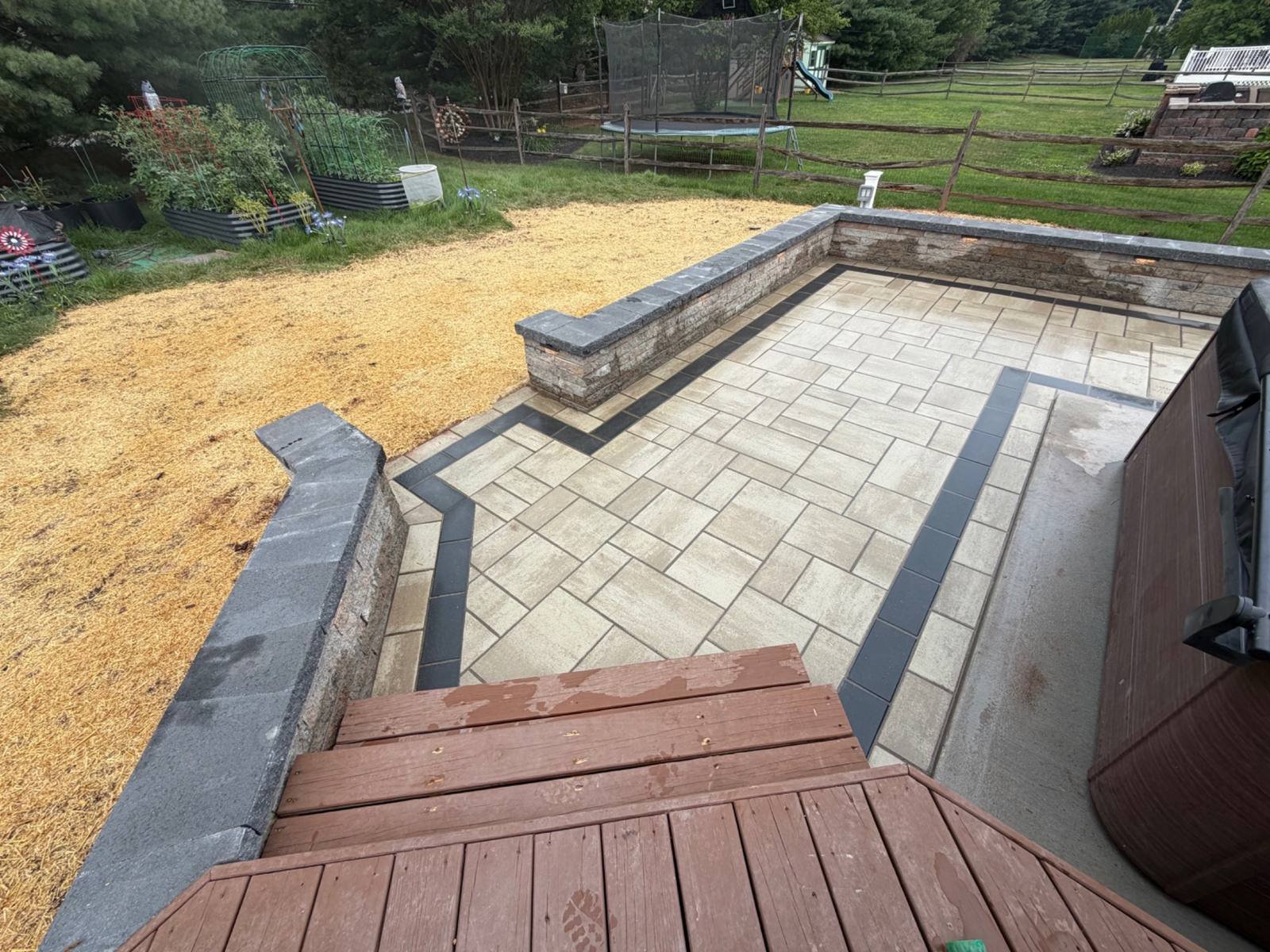 Custom paver walkway featuring a curved layout, contrasting stone borders, and low retaining walls that help define the outdoor space and accommodate changes in ground elevation.