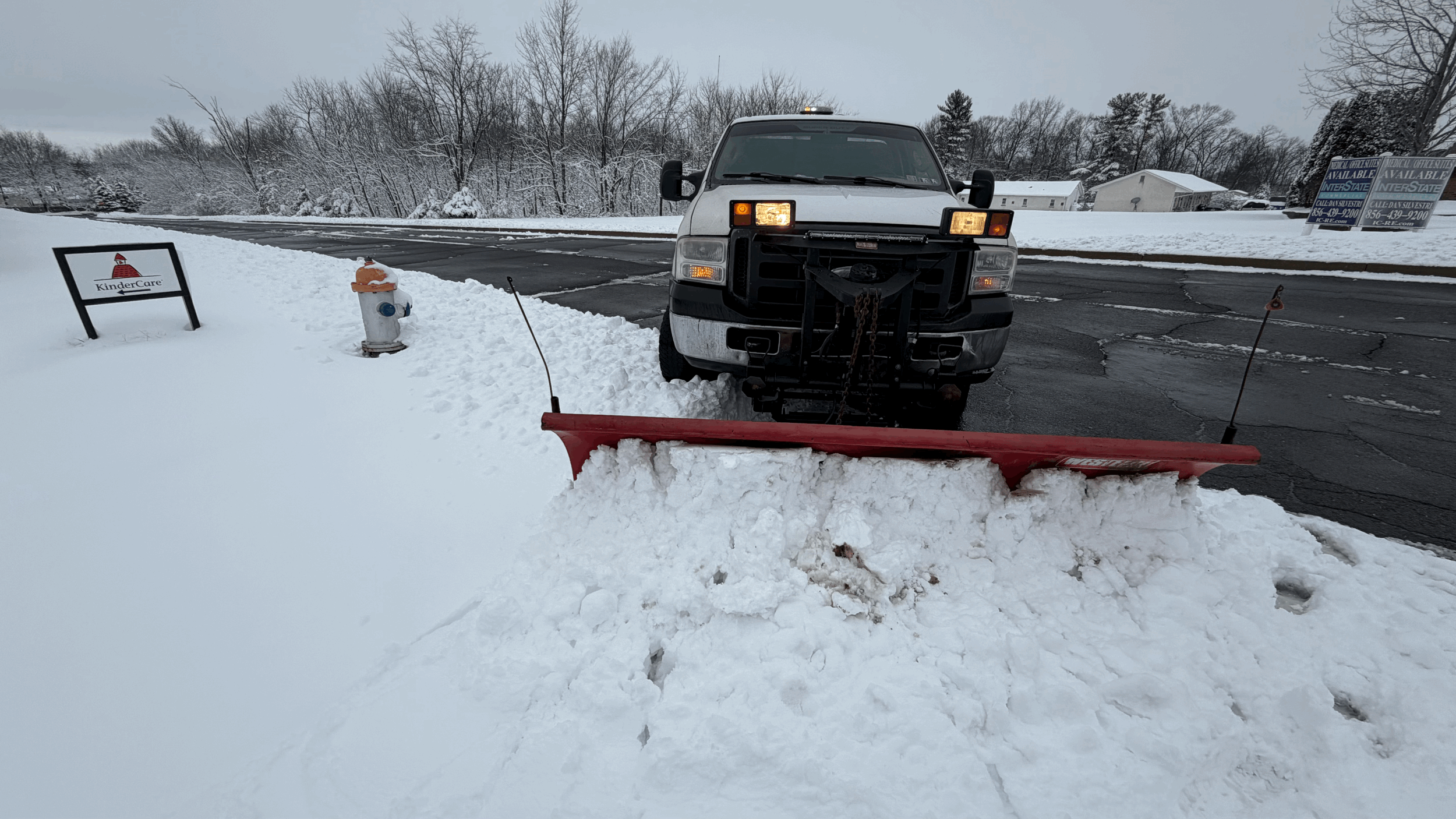 Heavy-duty pickup truck equipped with a front snow plow for clearing accumulated snow from residential driveways, parking lots, and access roads during winter storms.