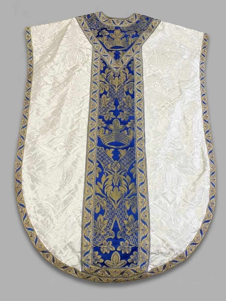 A white liturgical vestment with blue and gold intricate embroidery and patterns along the front center and edges.