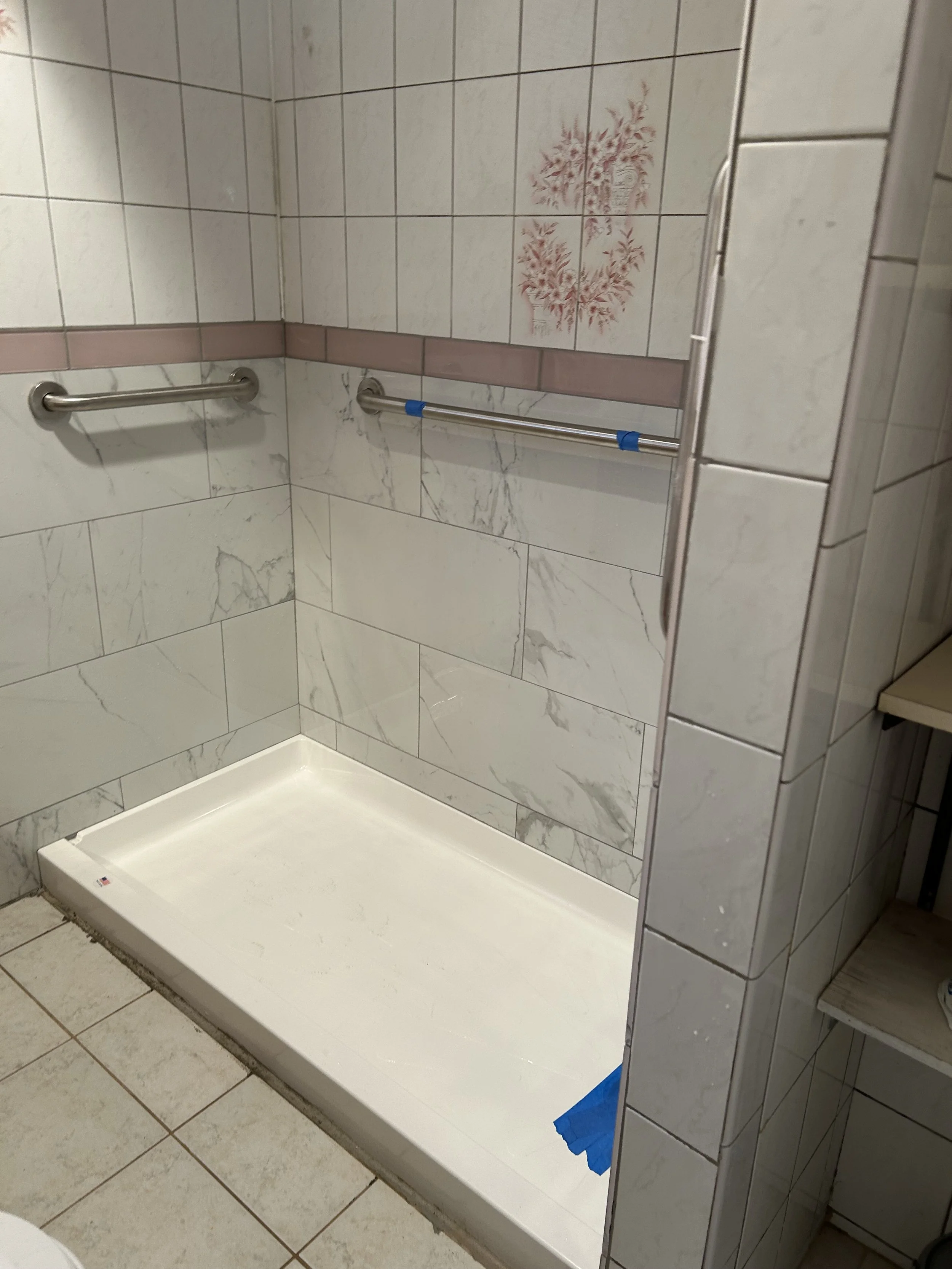 fully blocked hand holds, low curb shower pan, updated handheld shower with bar, half wall tile replacement. 