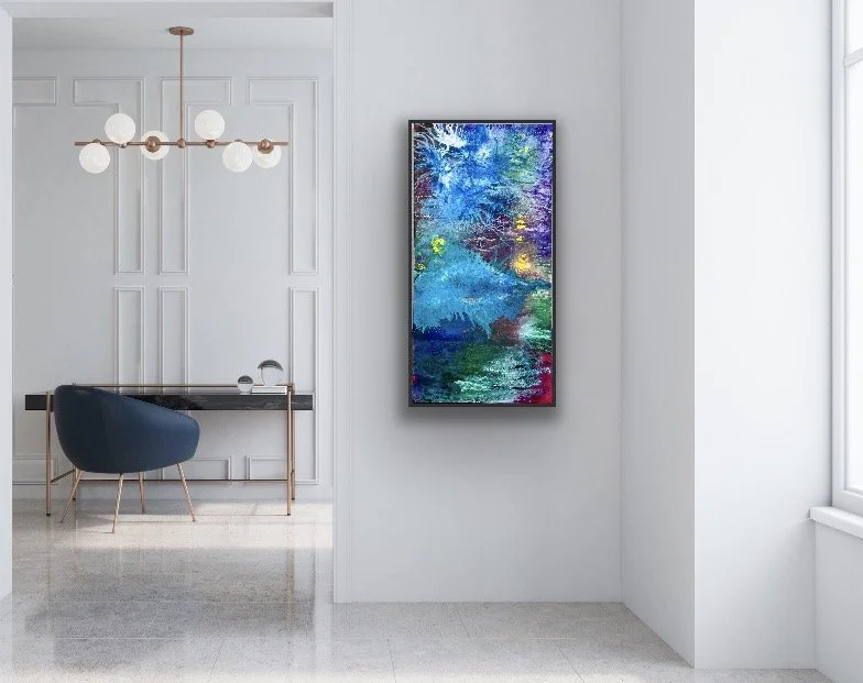 Modern interior with a wall-mounted colorful abstract art piece, a white wall, a large window, and a corner with a navy chair and a black desk.