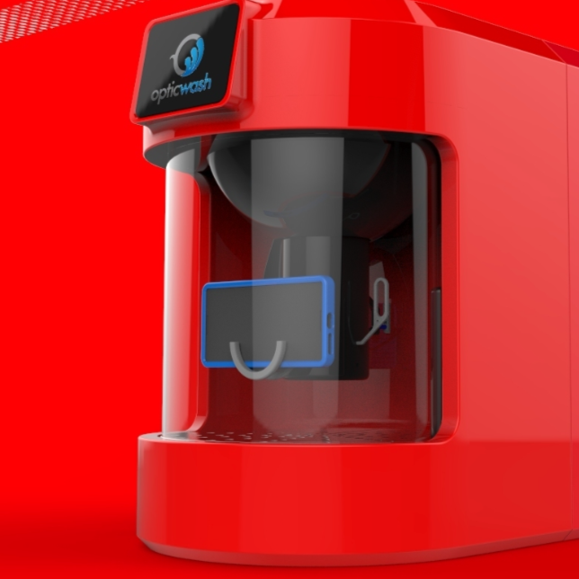 Close-up of a red ophthalmic machine labeled 'opticwash' with a transparent chamber and a tablet device inside.
