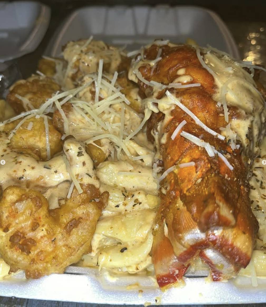 Fried chicken wings topped with cheese and sauce, served with pasta and shredded cheese.