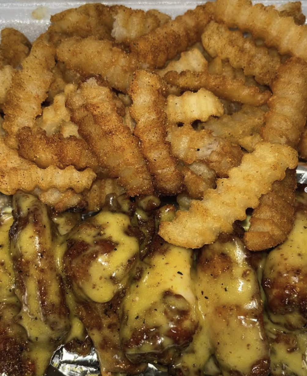 Fried chicken tenders and crinkle-cut French fries with melted cheese and barbecue sauce.