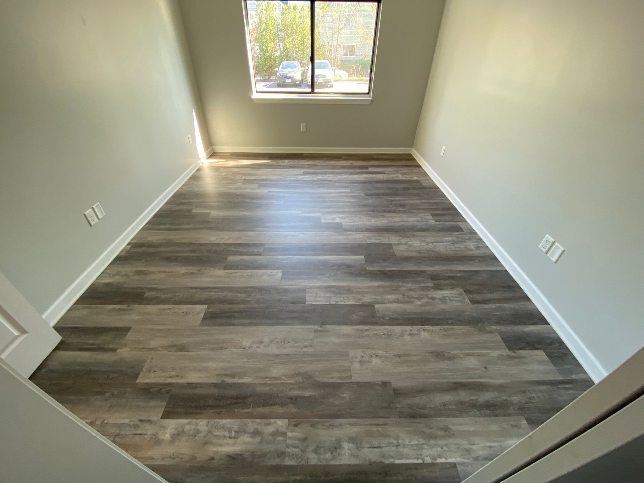 Renovated room with finished walls, wood flooring, and natural light.