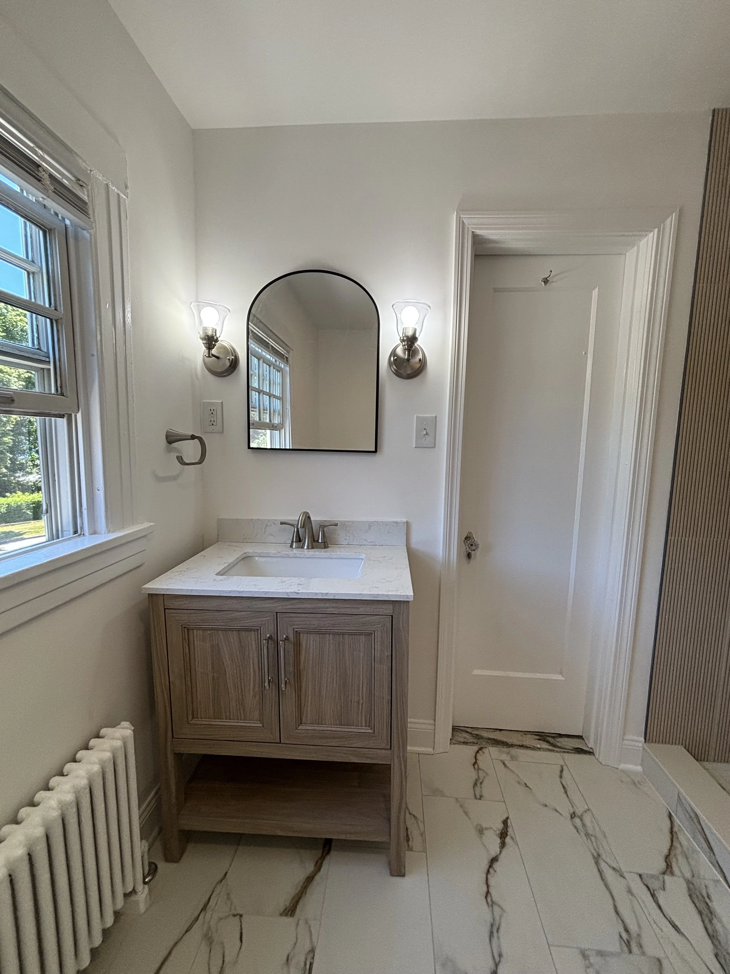 Finish bathroom renovation with vanity, mirror, lighting, tile flooring, and modern light.