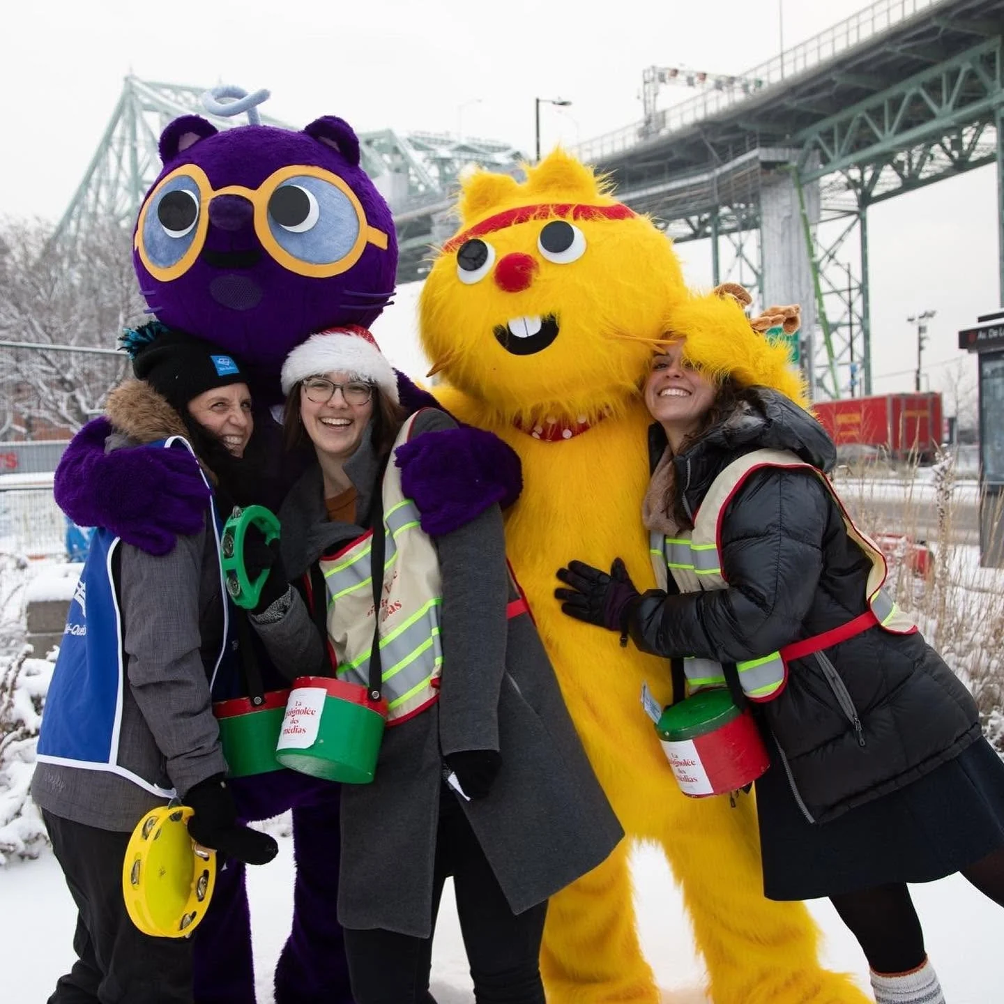 Quatre personnes déguisées en personnages de dessins animés, avec deux mascottes en costume, dans un environnement enneigé