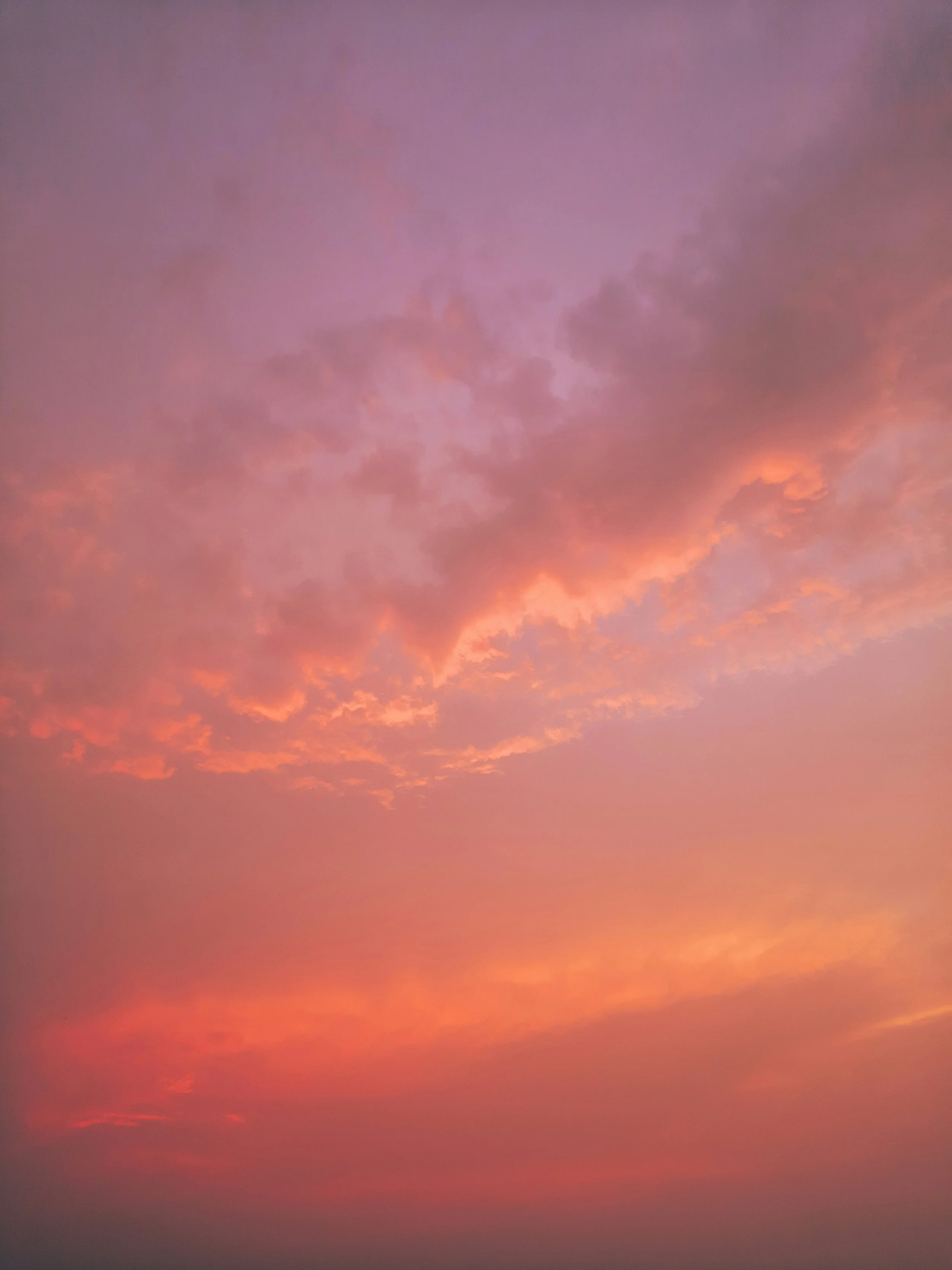 A colorful sky during sunset or sunrise with shades of purple, pink, orange, and red, and some clouds.
