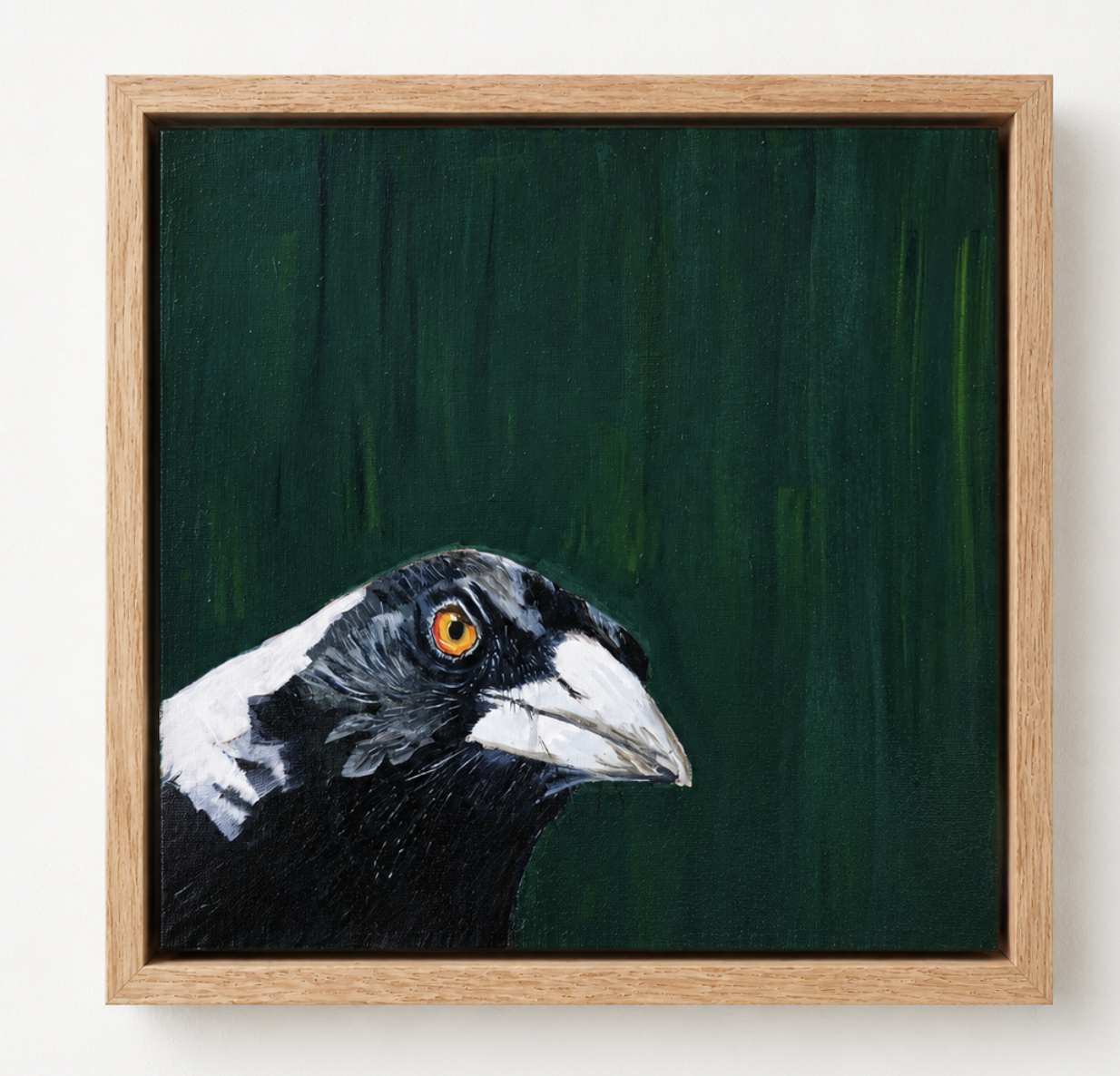 Painting of a bird's head, likely a crow or raven, with a yellow eye, on a dark green background, framed in wood.