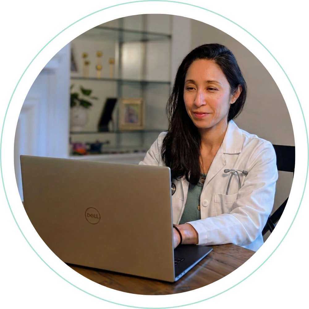 Dr. Jennifer Chung in a white coat during a telehealth visit on her laptop