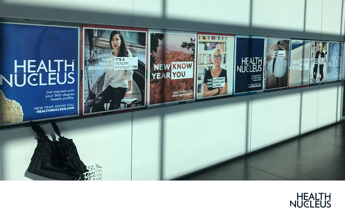 A series of health-related posters displayed on a wall, promoting health awareness and programs from Health Nucleus.