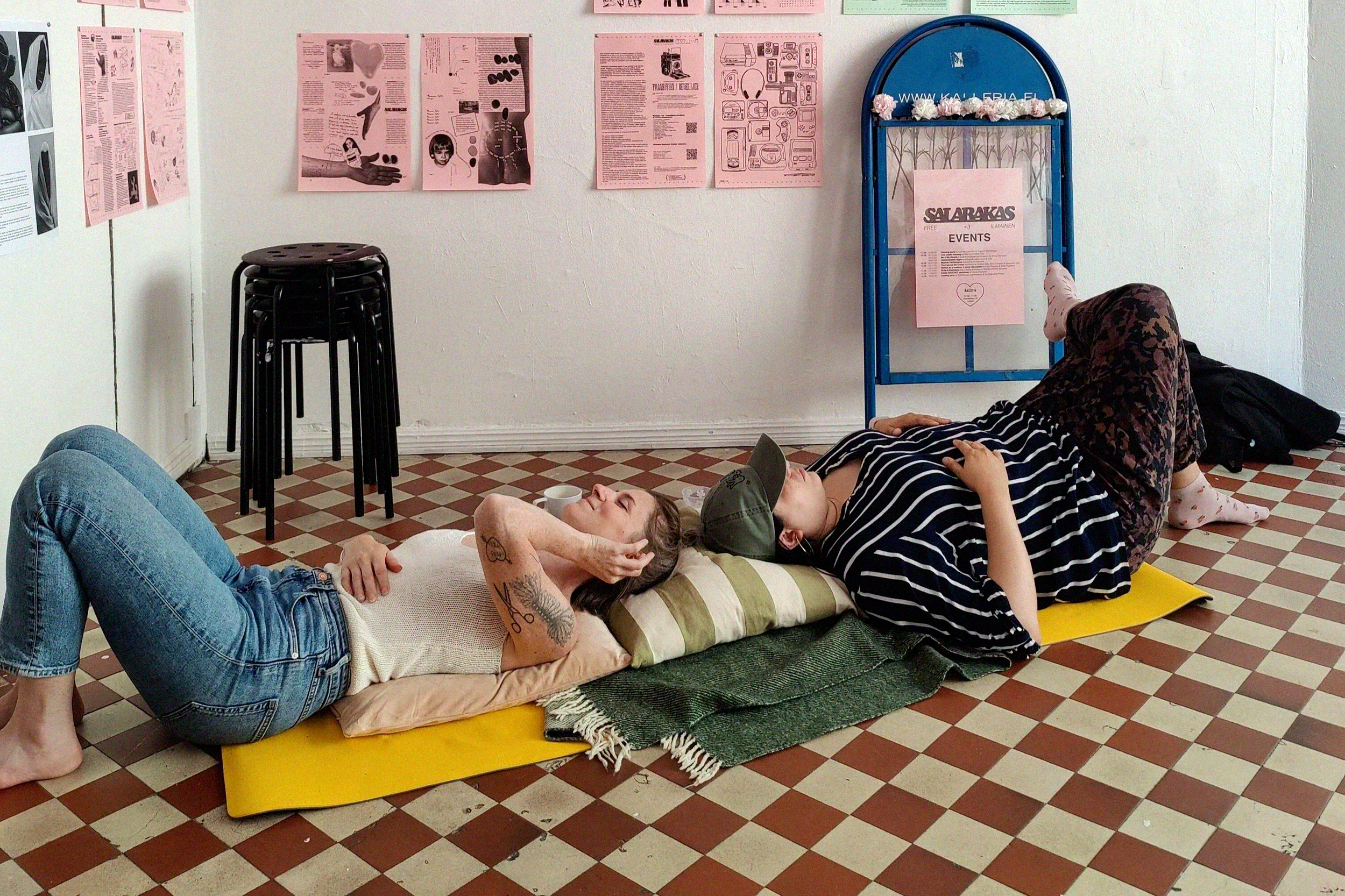 Two people laying down comfortably on a floor and smiling