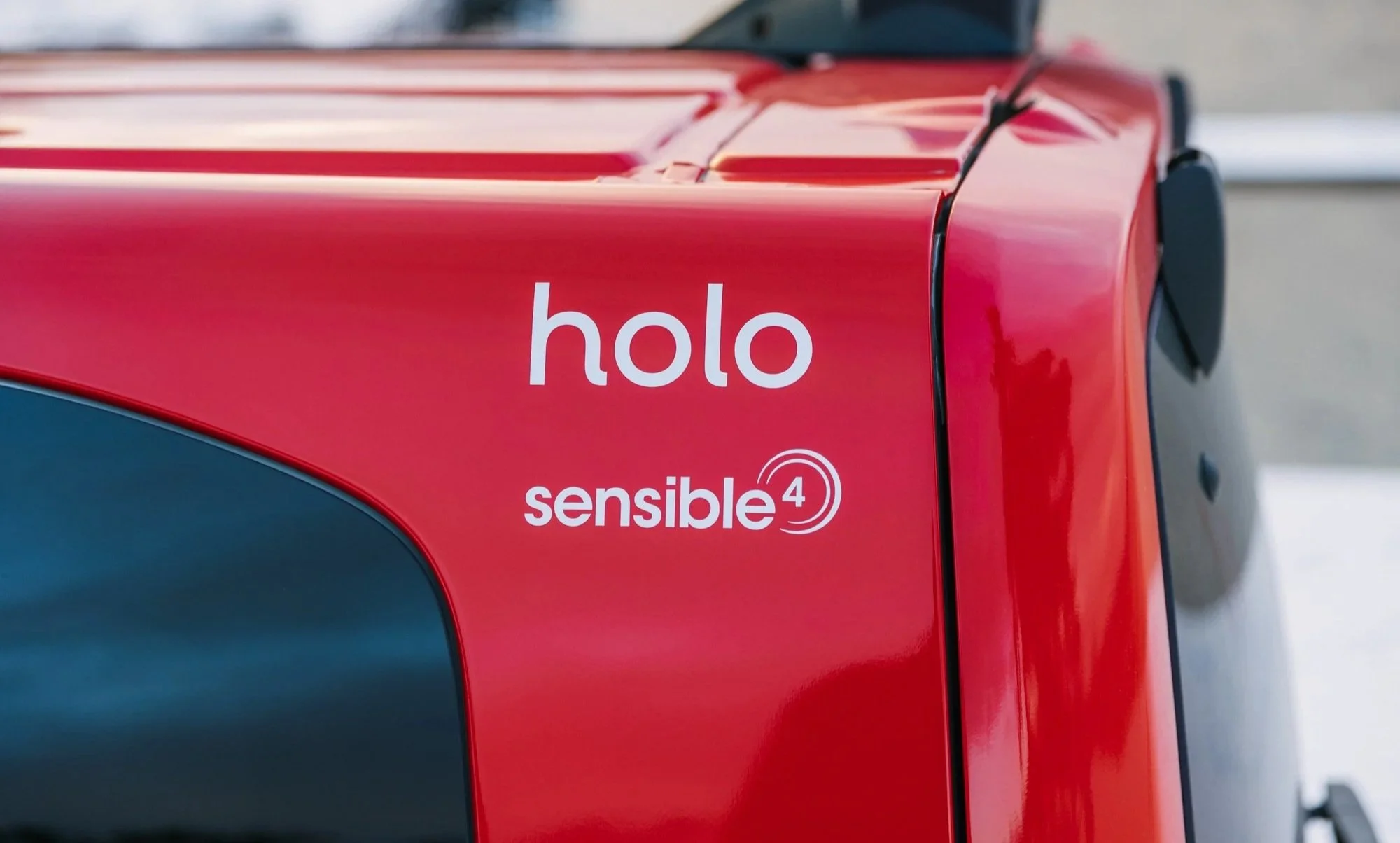 Close-up of a red vehicle with the word 'holo' and the phrase 'sensible 4' on the side.