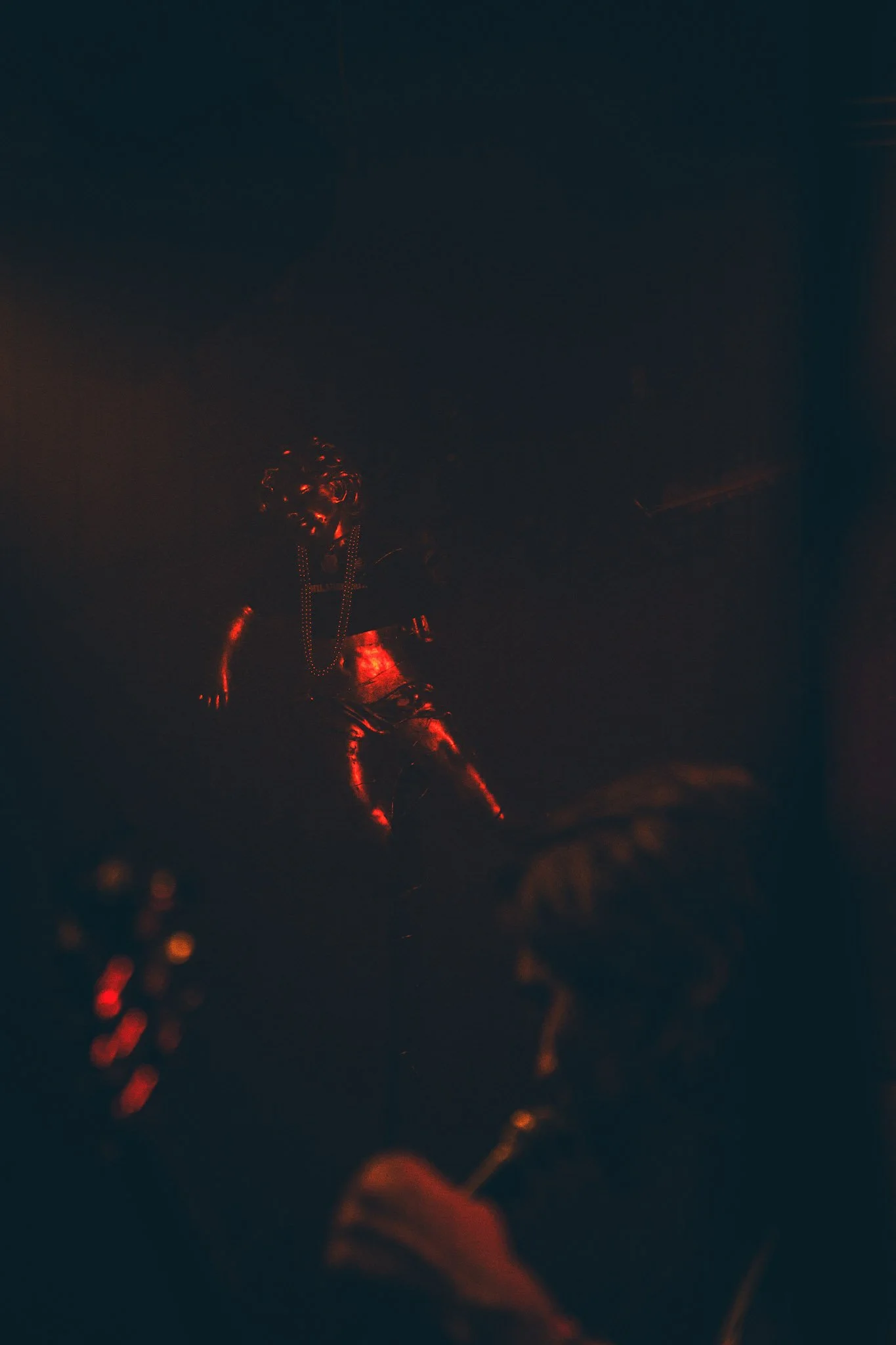 Low light image of a person with red LED lights on various parts of their body, possibly a costume or decorative attire.