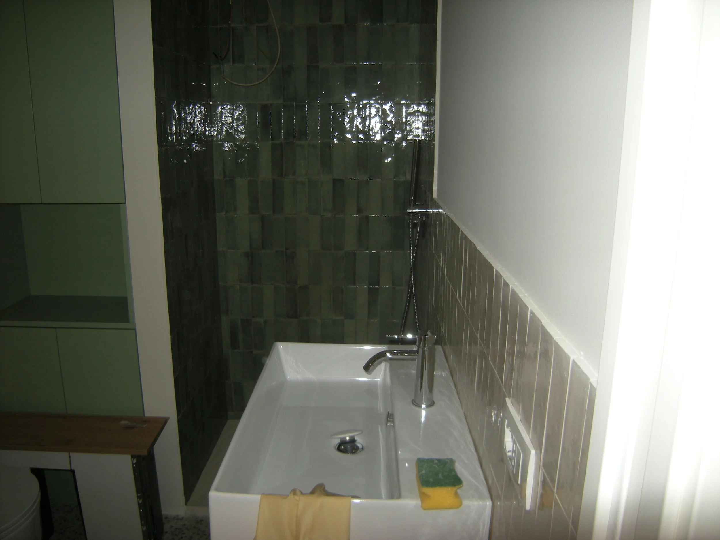 Foto di una stanza da bagno con una vasca, un rubinetto e alcune scaffalature sulla sinistra.