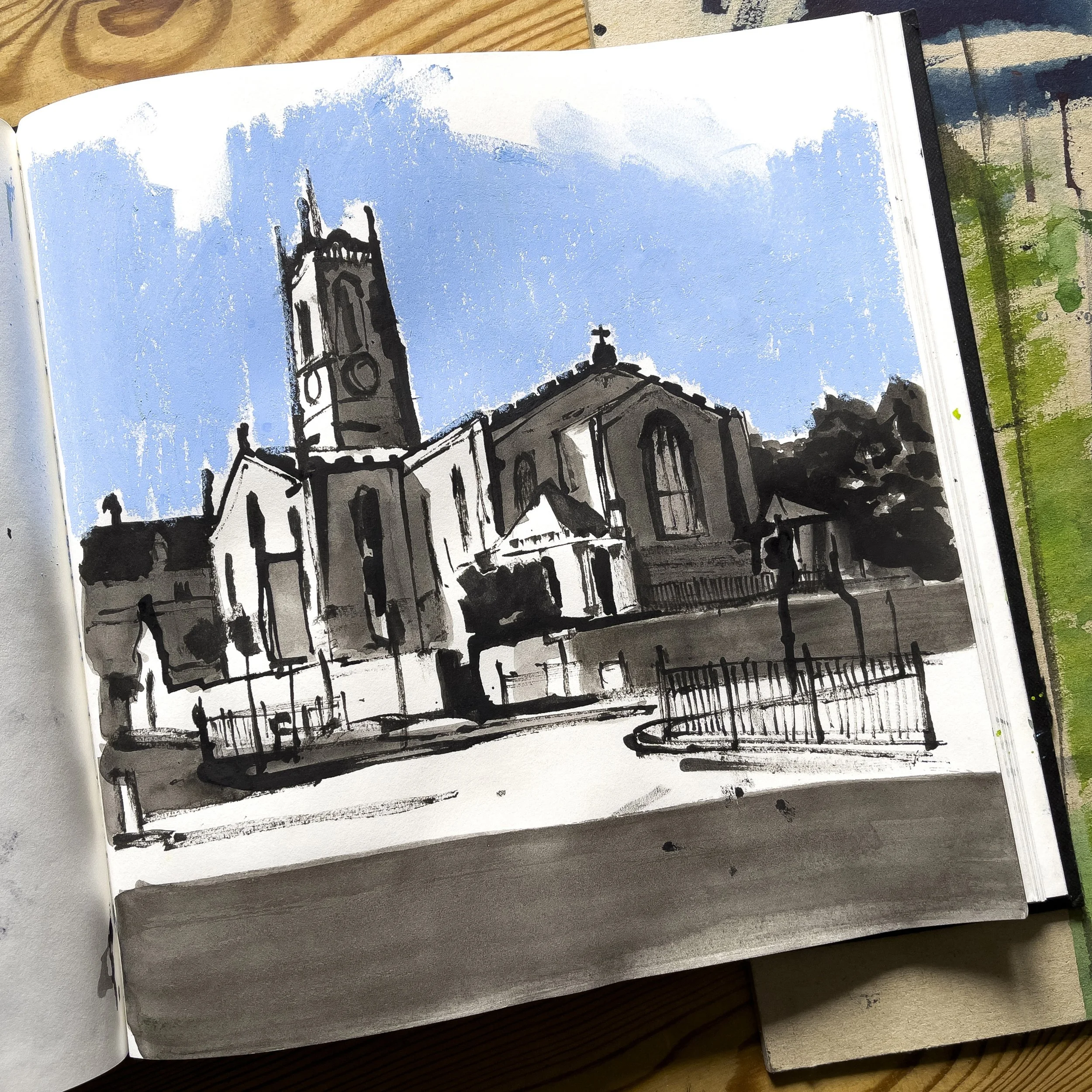 Black-and-white architectural sketch of a historic church with a tall bell tower, surrounded by iron railings under a blue sky.