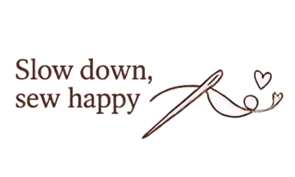 Colorful embroidered text reading 'Slow down, sew happy' with a sewing needle and thread, and a small white heart.