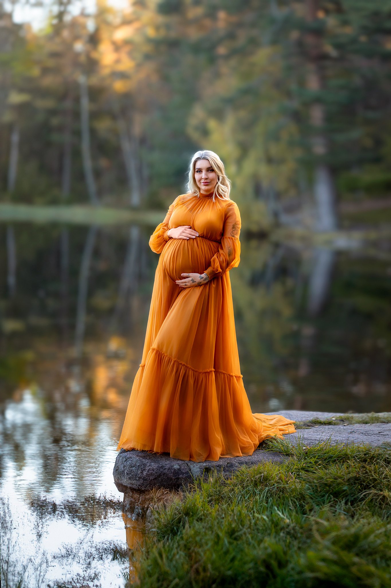 Gravid kvinne i oransje kjole i høstallé – gravidfotografering i Oslo