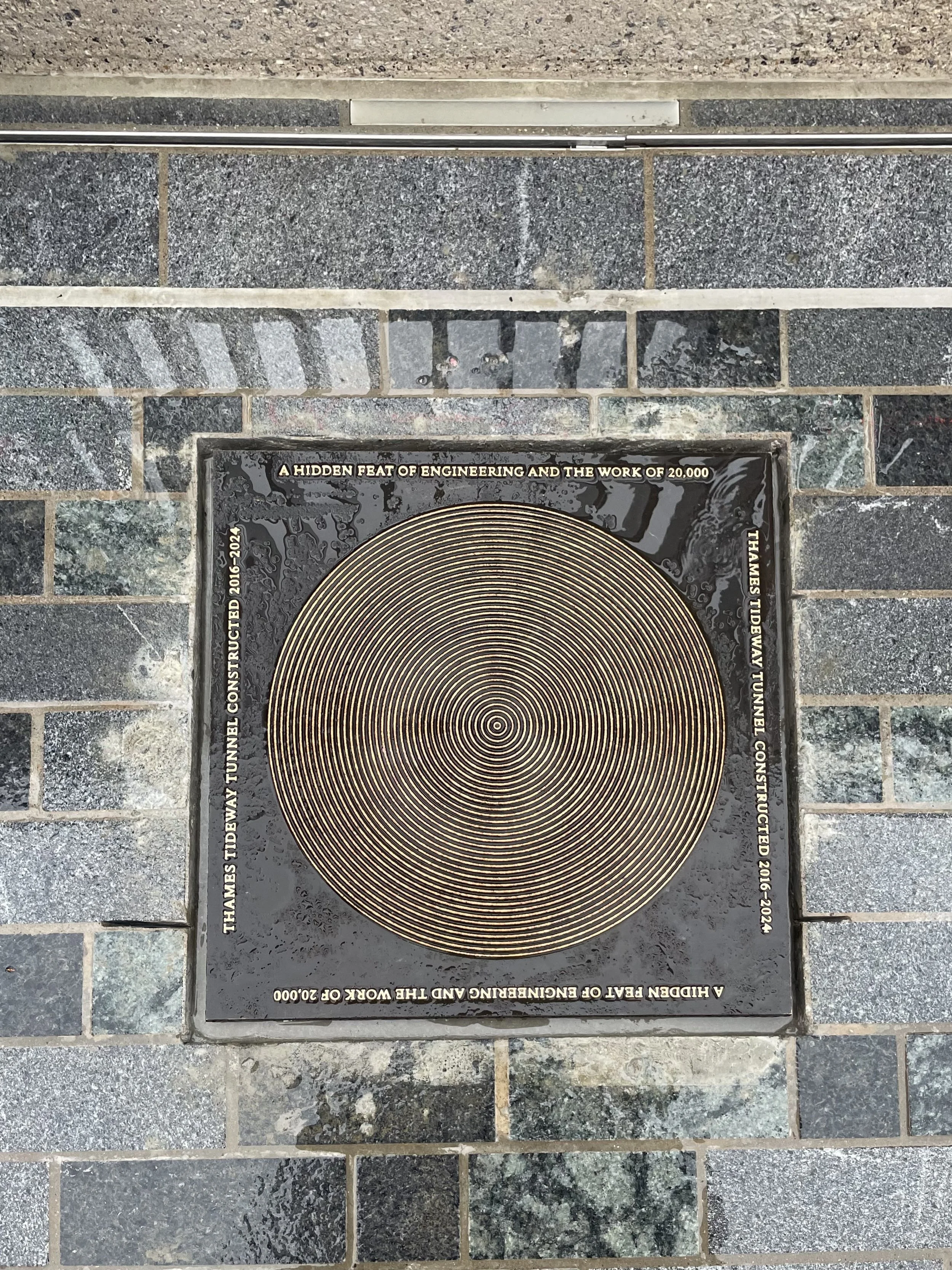 Marina Willer’s concentric-circle Tideway bronze street cover installed in paving in London.