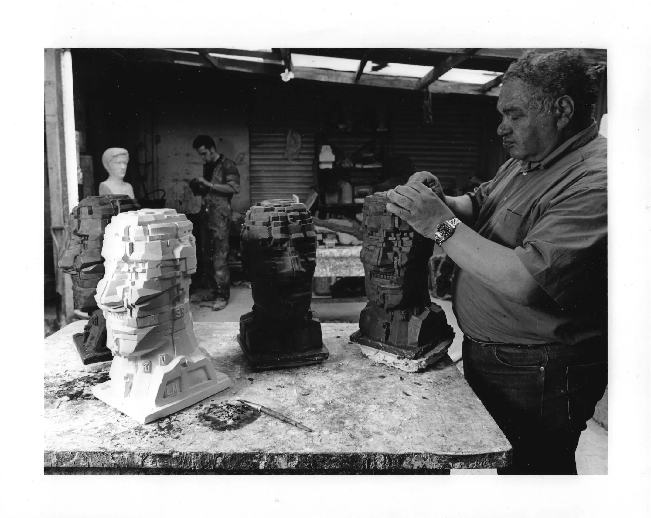 Sir Eduardo Paolozzi working on plaster and wax versions of the Head, 1993, together on the workbench at Arch Bronze.
