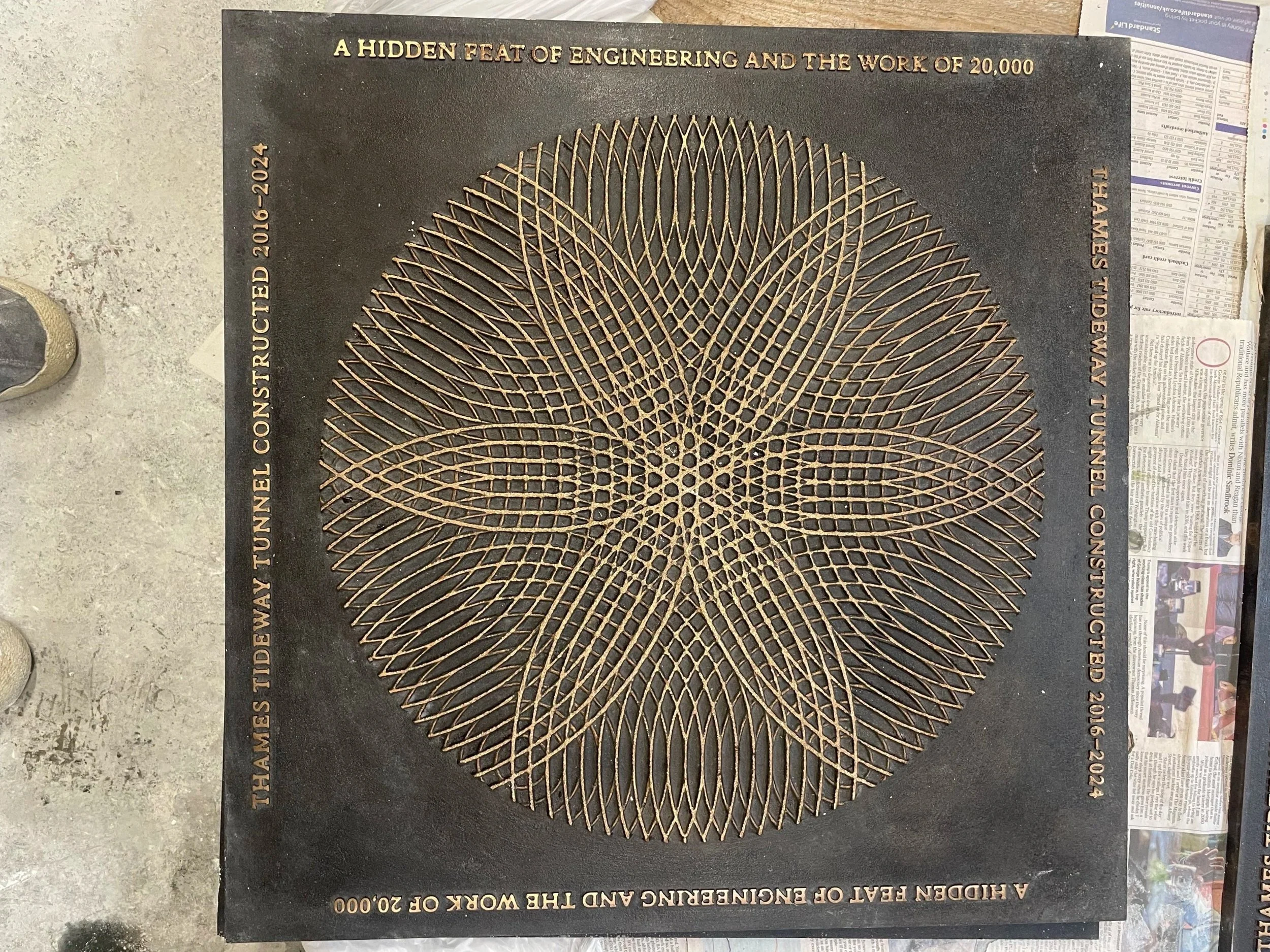 Moiré-pattern Tideway bronze street cover designed by Marina Willer of Pentagram, finished at Arch Bronze.
