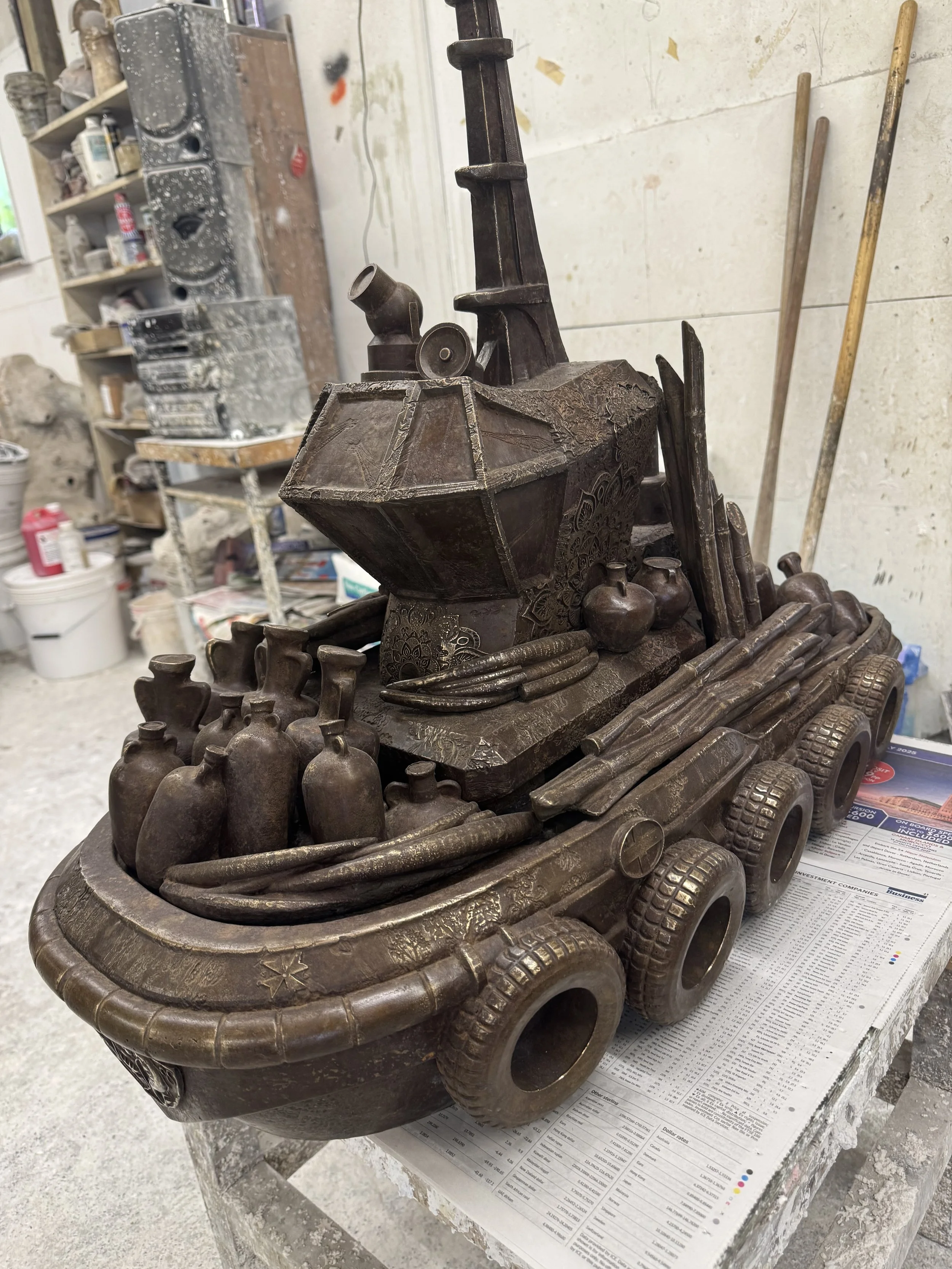 Hew Locke bronze workboat from Cargoes at Arch Bronze, loaded with vessels, timber and tyre fenders.