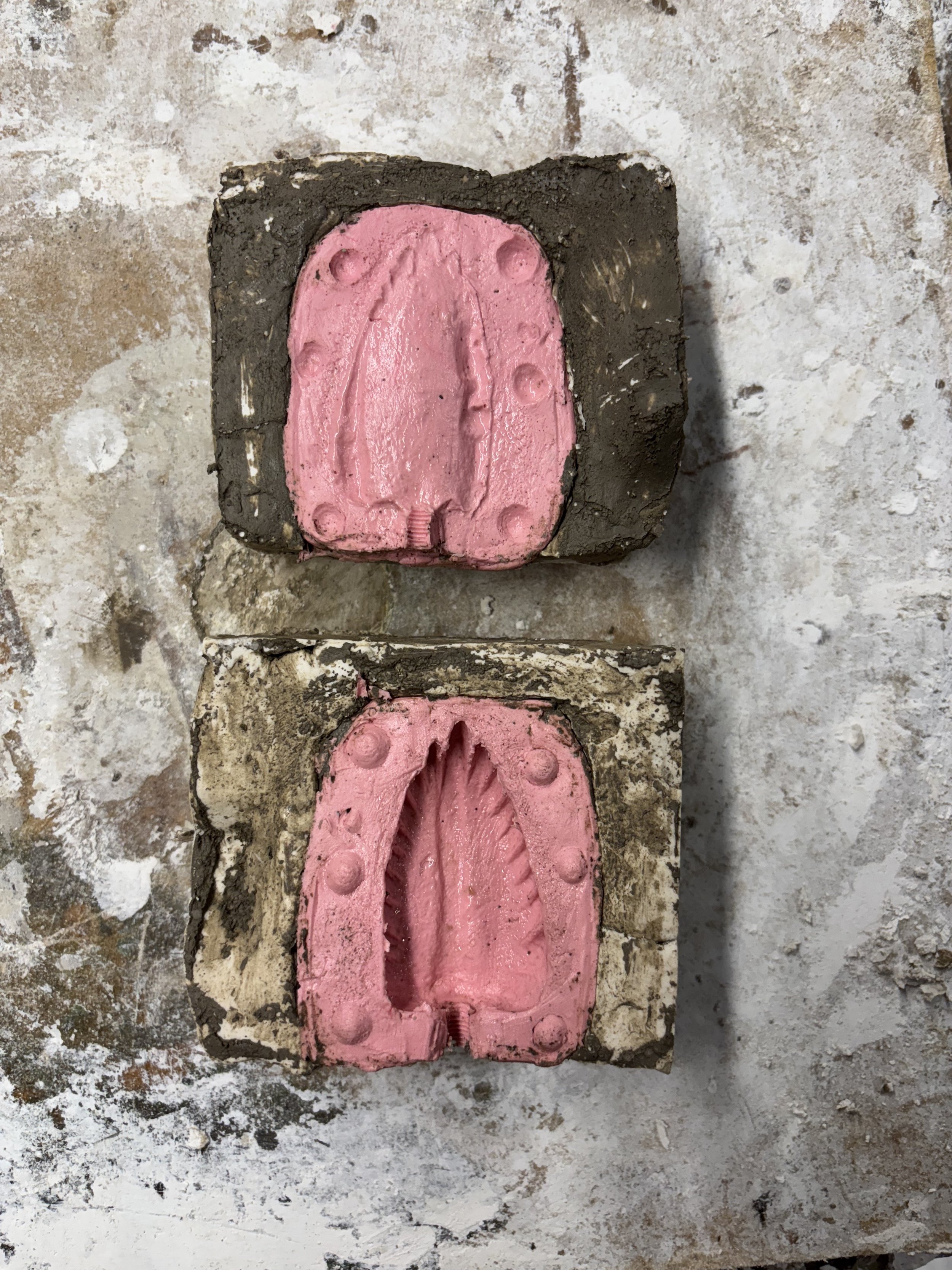 Concrete molds with pink silicone in the shape of a shoe soles.