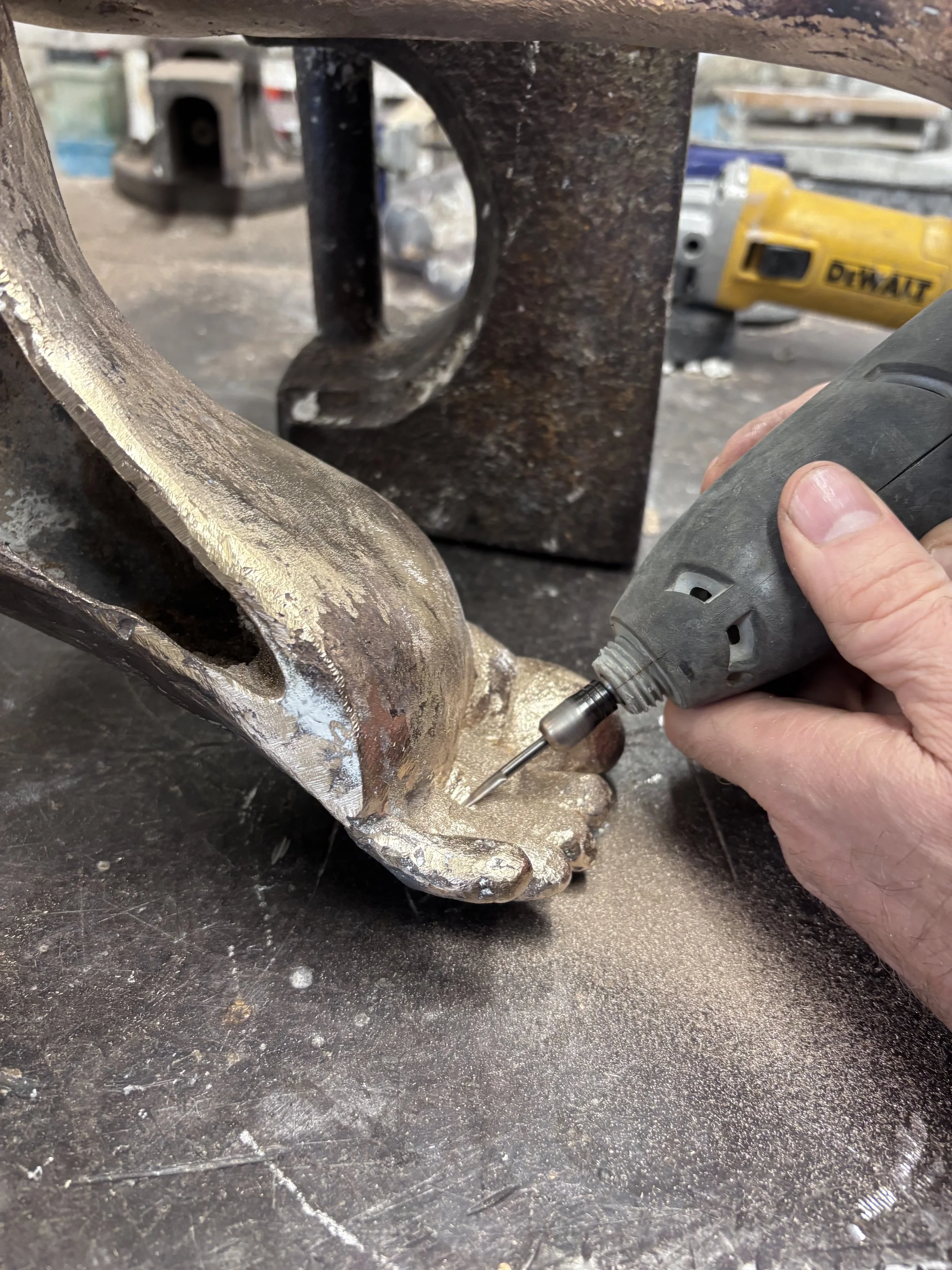 Close-up of a person using a rotary tool on a piece of metal.