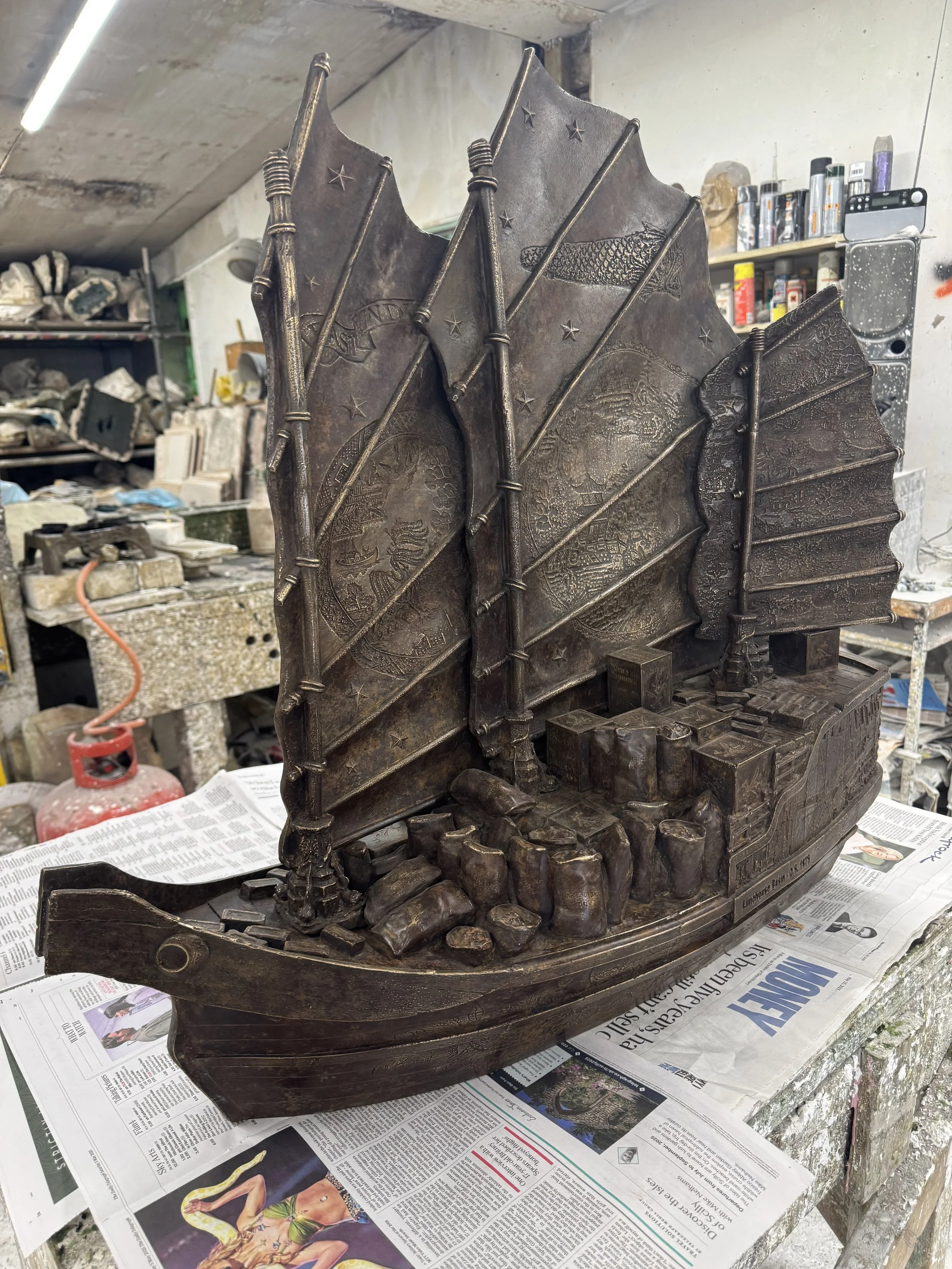 Hew Locke bronze boat sculpture from Cargoes at Arch Bronze, with tall layered sails and detailed relief decoration.