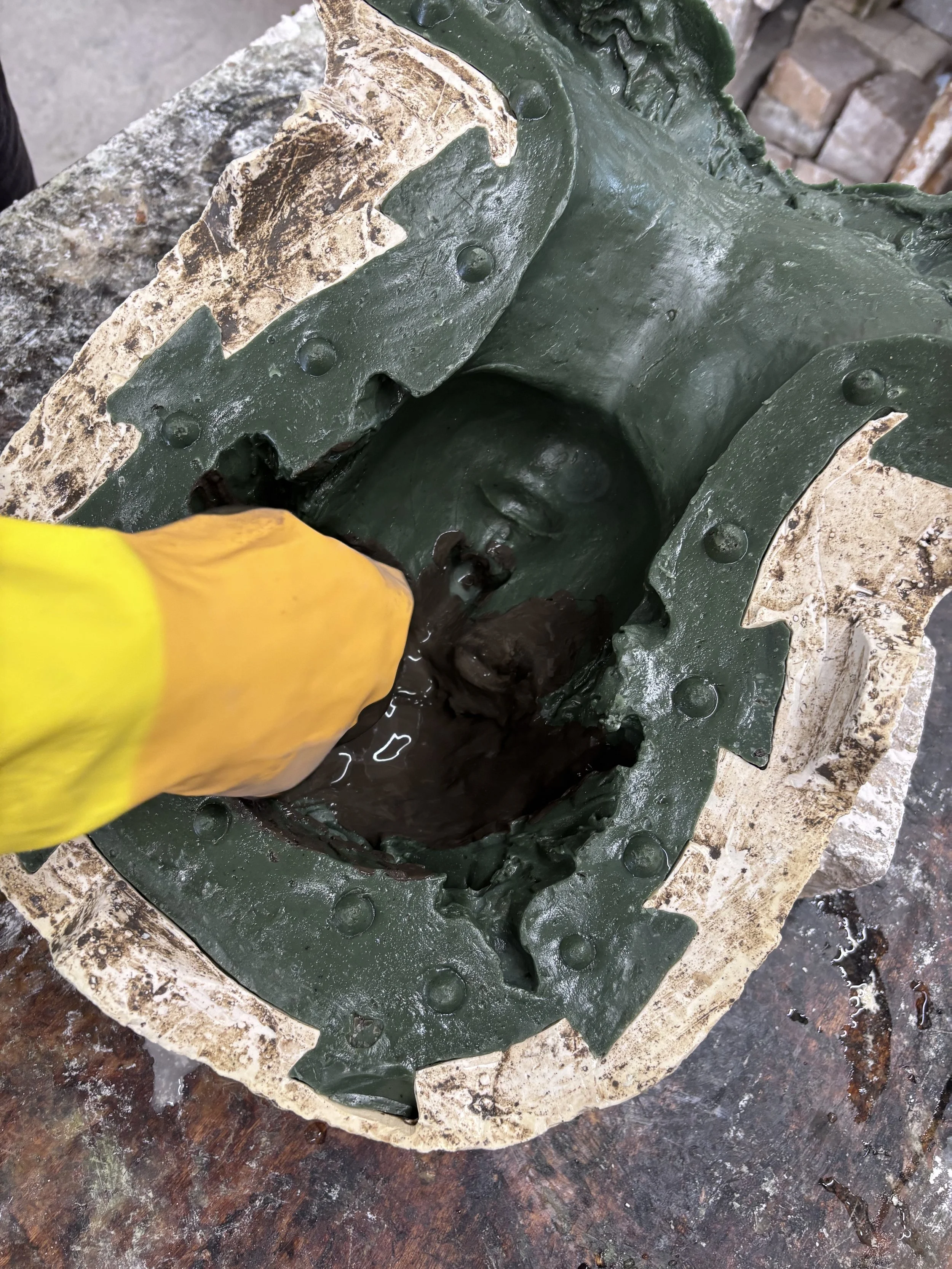 Cement being applied by hand into a mould at Arch Bronze.