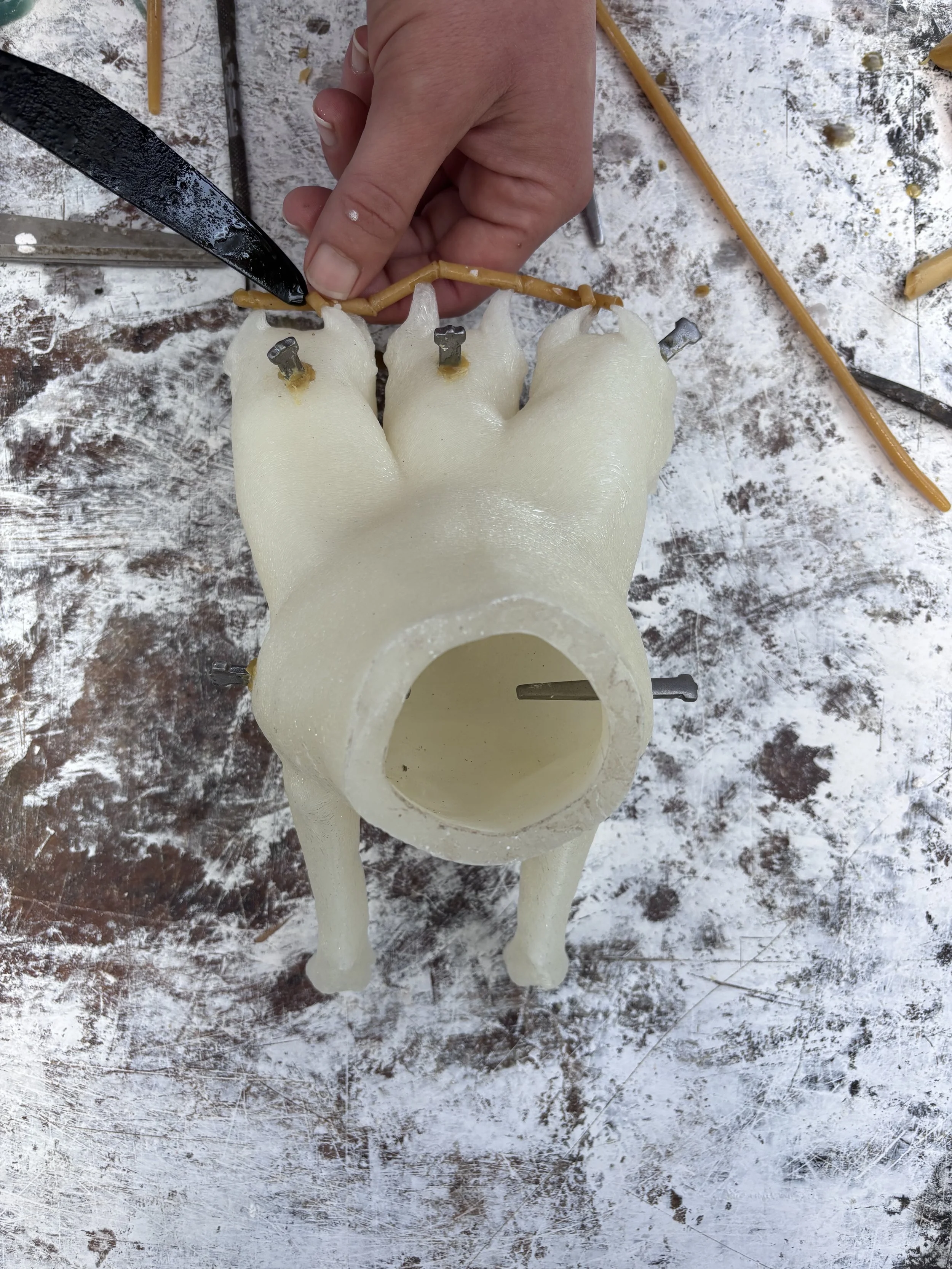 A 3D printed model being prepared with wax feeds for lost wax casting as a prototype.