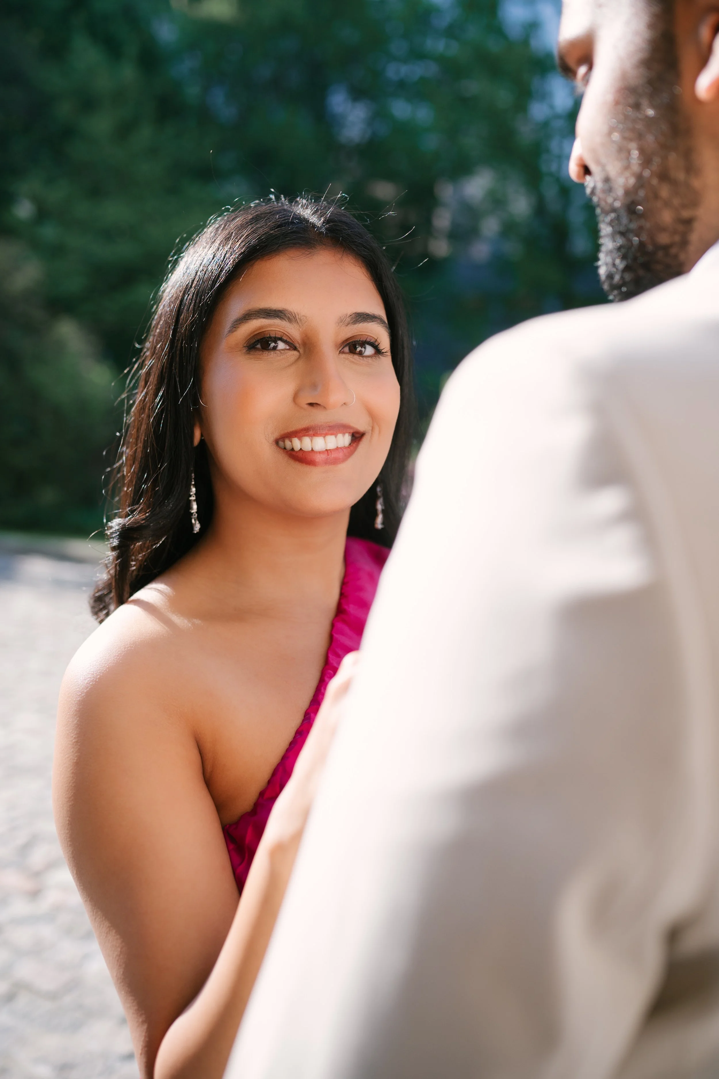 A woman smiling at a man outdoors.