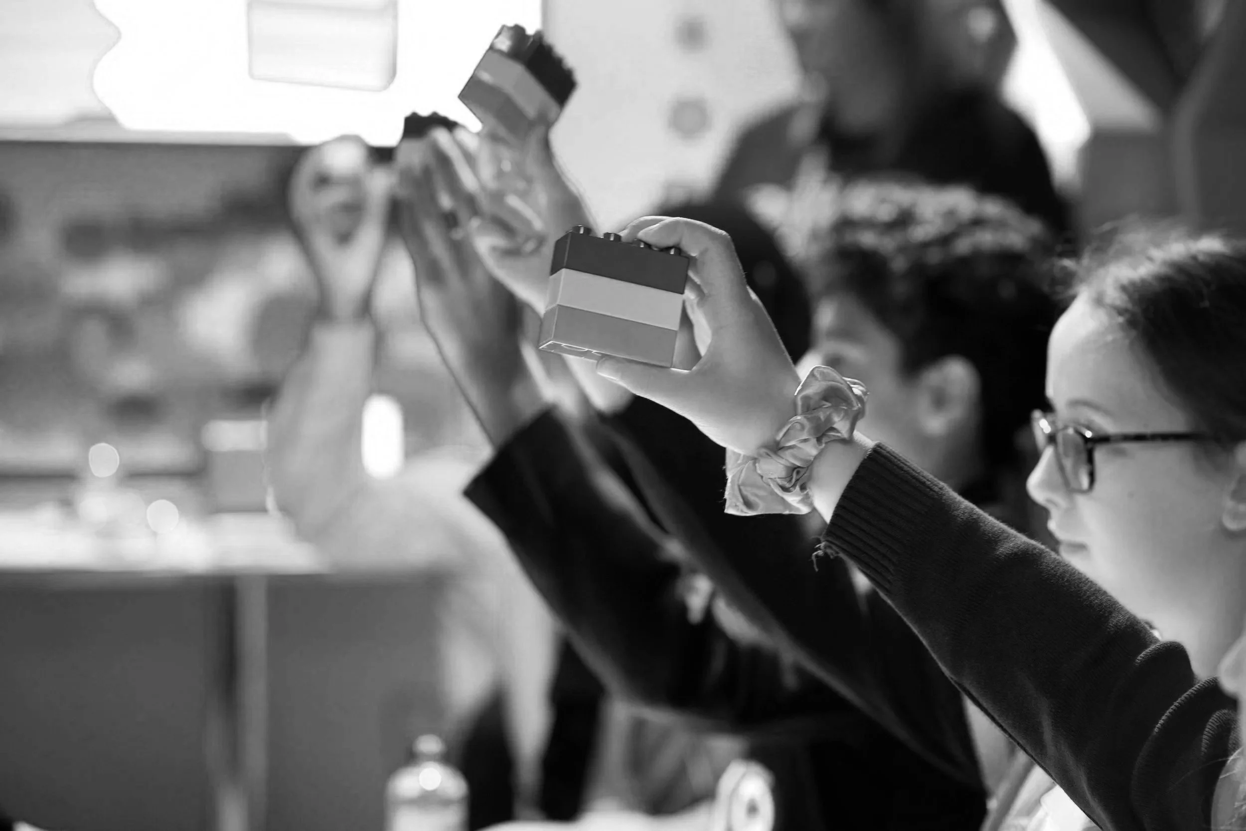 Students at the LEGO Build the Change Youth Council proudly hold up a stack of duplo bricks as part of a learning through play workshop.