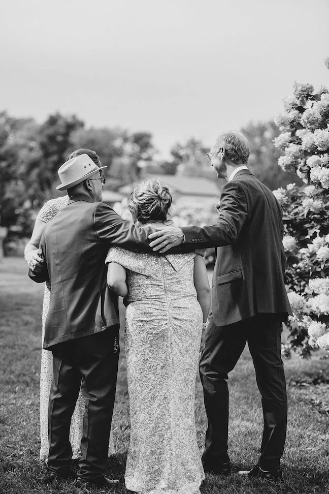 brides parents and grooms parents sharing intimate moment