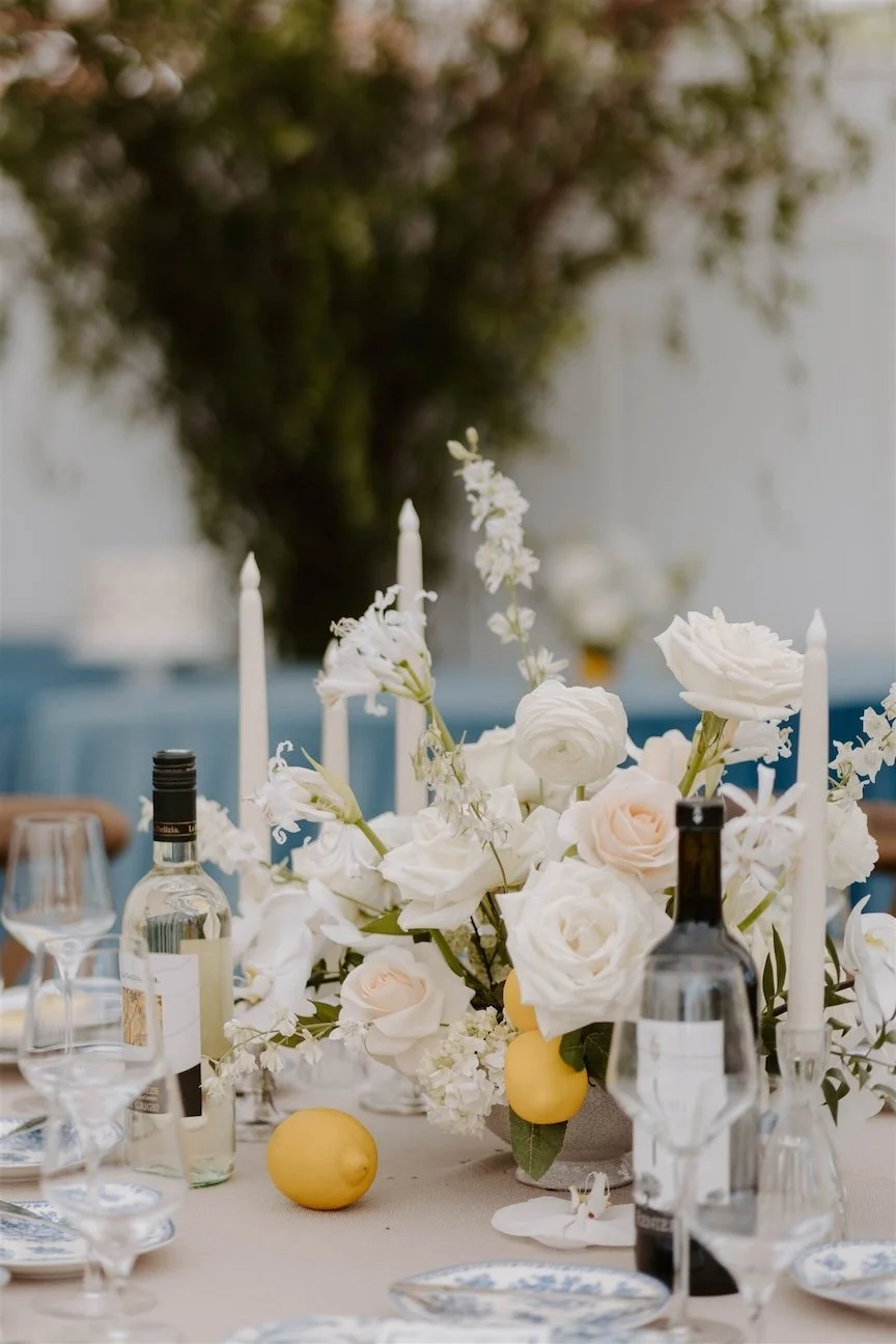 Beautiful white rose centerpieces surrounded by lemons and blue and white china